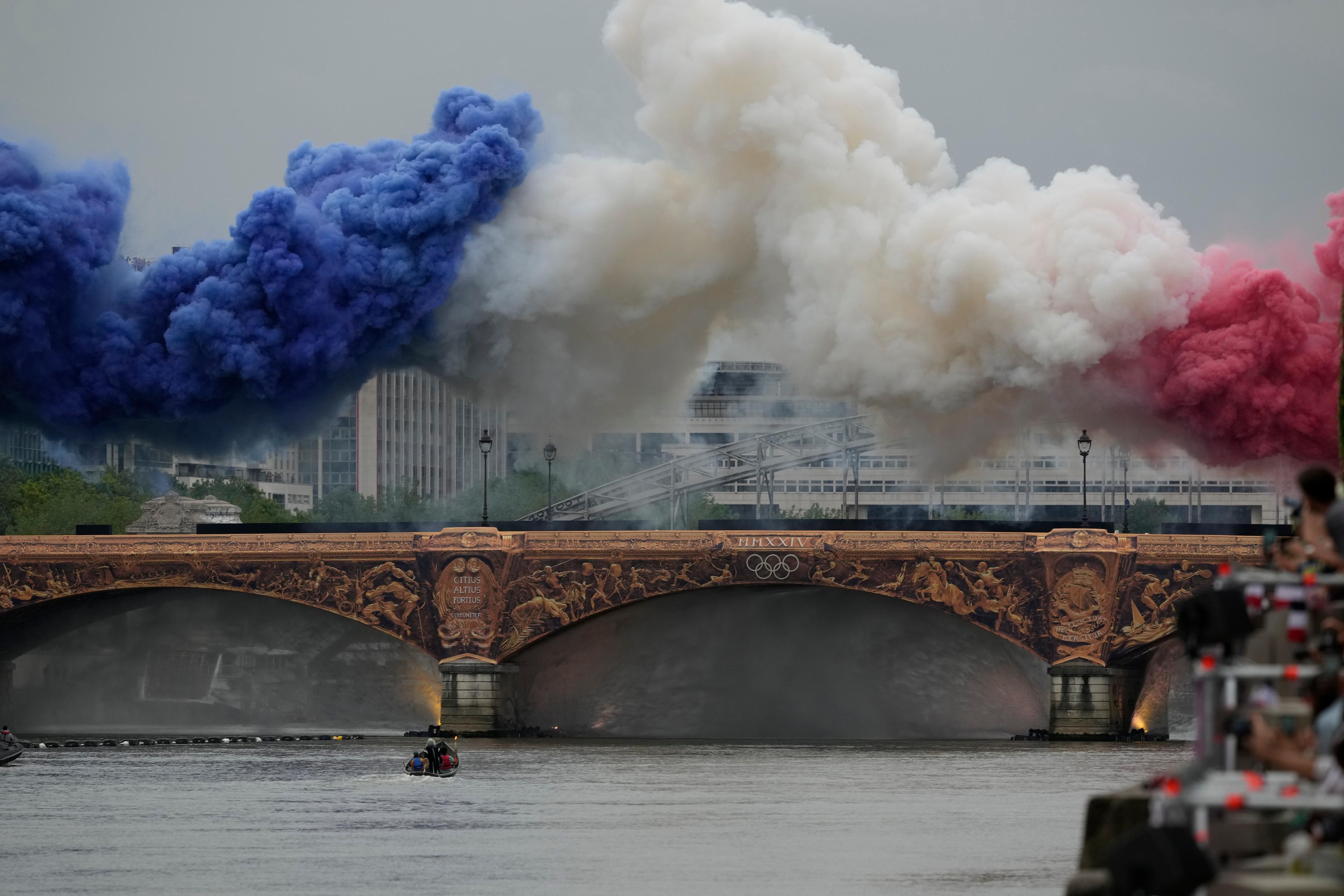 Färgad rök pryder bron när Grekland som första nation inleder paraden längs floden Seine. Foto: Luca Bruno/AP/TT