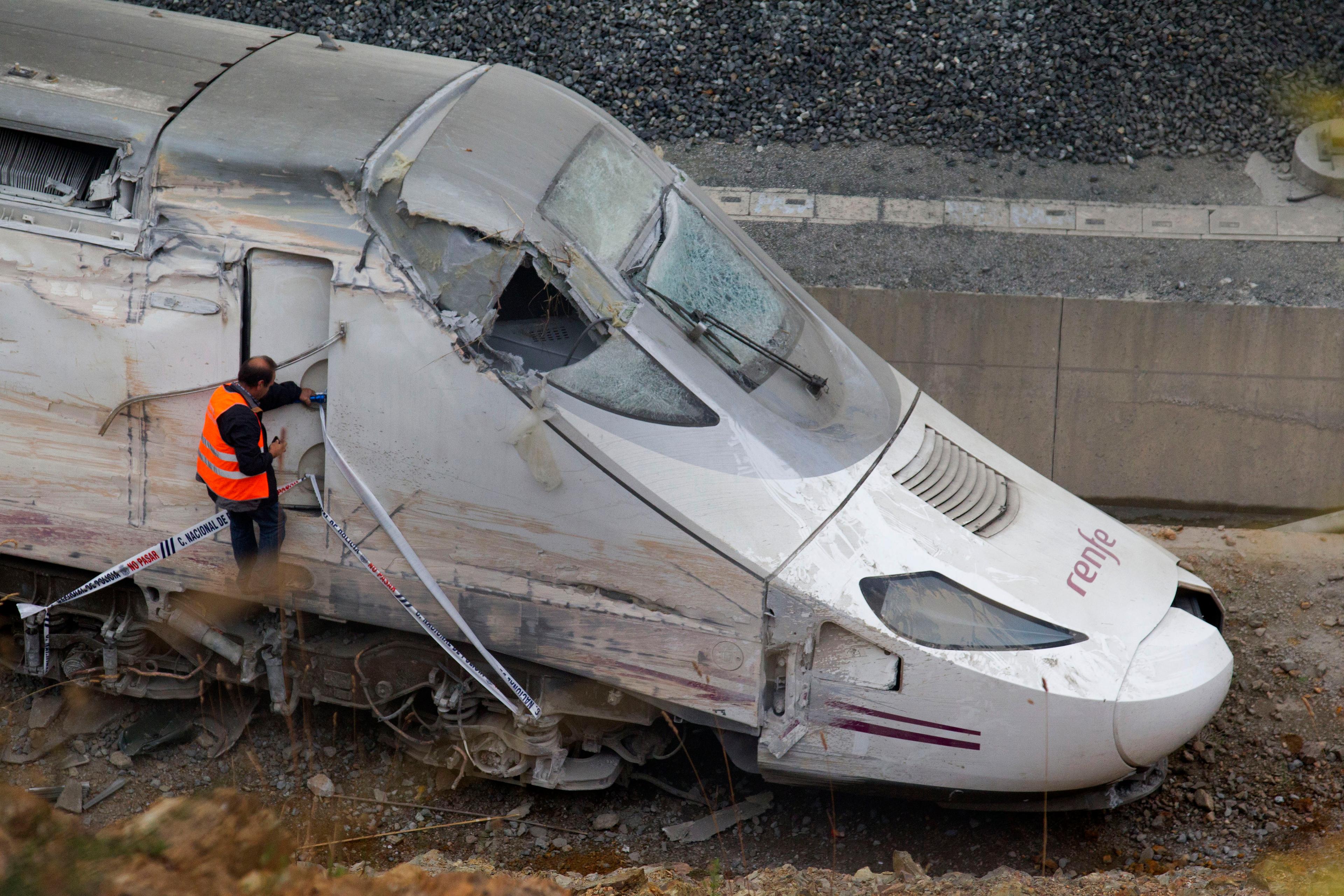 En av tågbolagets anställda undersöker förarhytten på det urspårade spanska olyckståget 2013. Foto: Lalo R. Villar/AP/TT