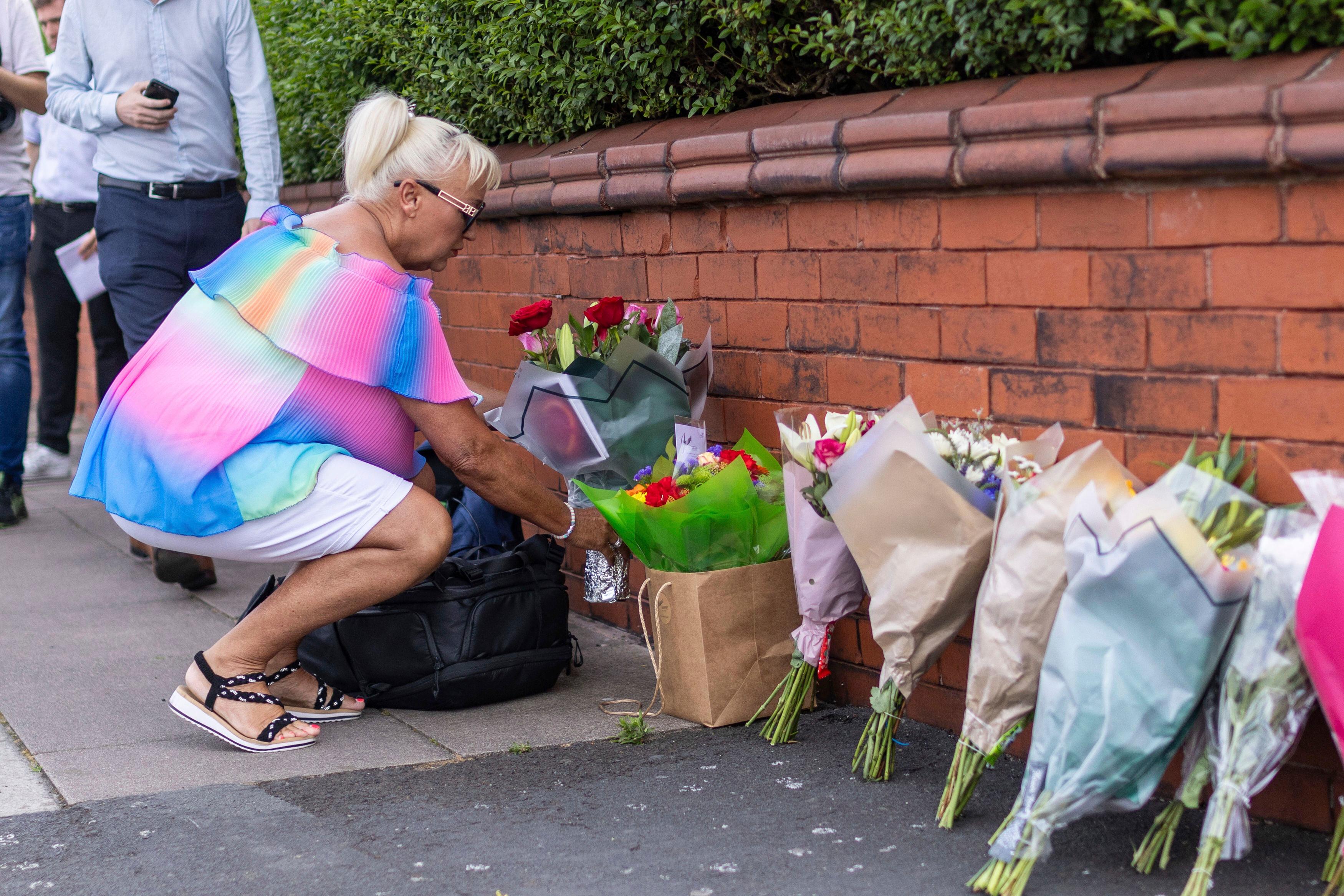 En kvinna lämnar blommor nära platsen där tre barn dödades och flera andra skadades i en knivattack i staden Southport i Storbritannien under måndagen. Foto: James Speakman/AP/TT