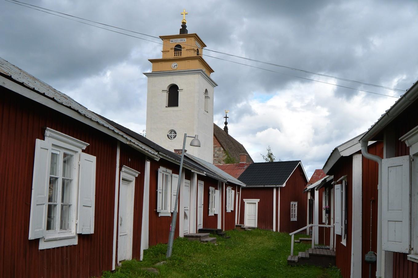 Det myllrar av röda, små kyrkstugor i Gammelstad kyrkstad. Klocktornet invid Nederluleå kyrka syns vida omkring. Foto: Eva Sagerfors