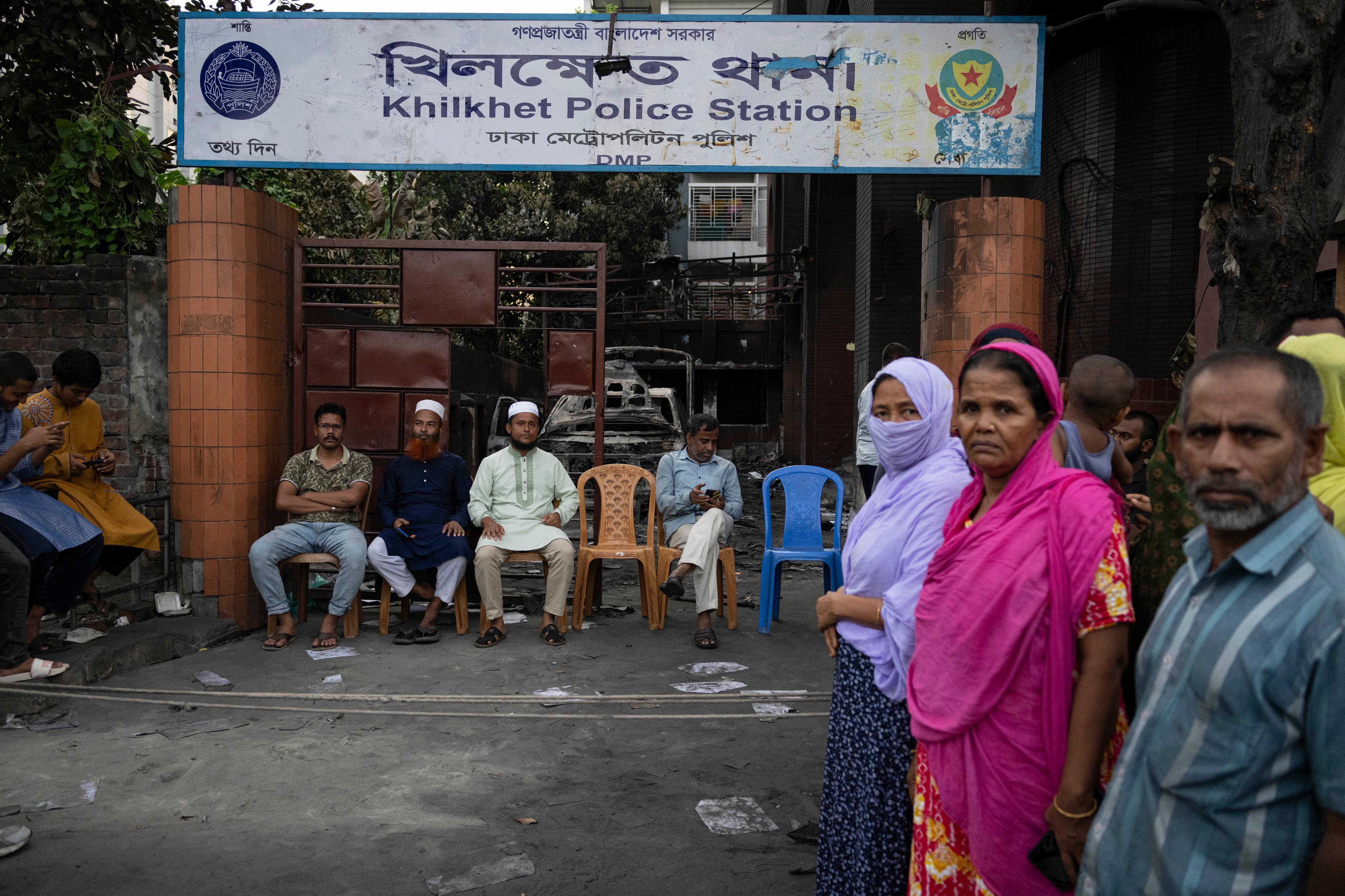 Vakter utanför en delvis sönderslagen polisstation efter kravallerna i Bangladeshs huvudstad Dhaka. Foto: Fatima Tuj Johora/AP/TT