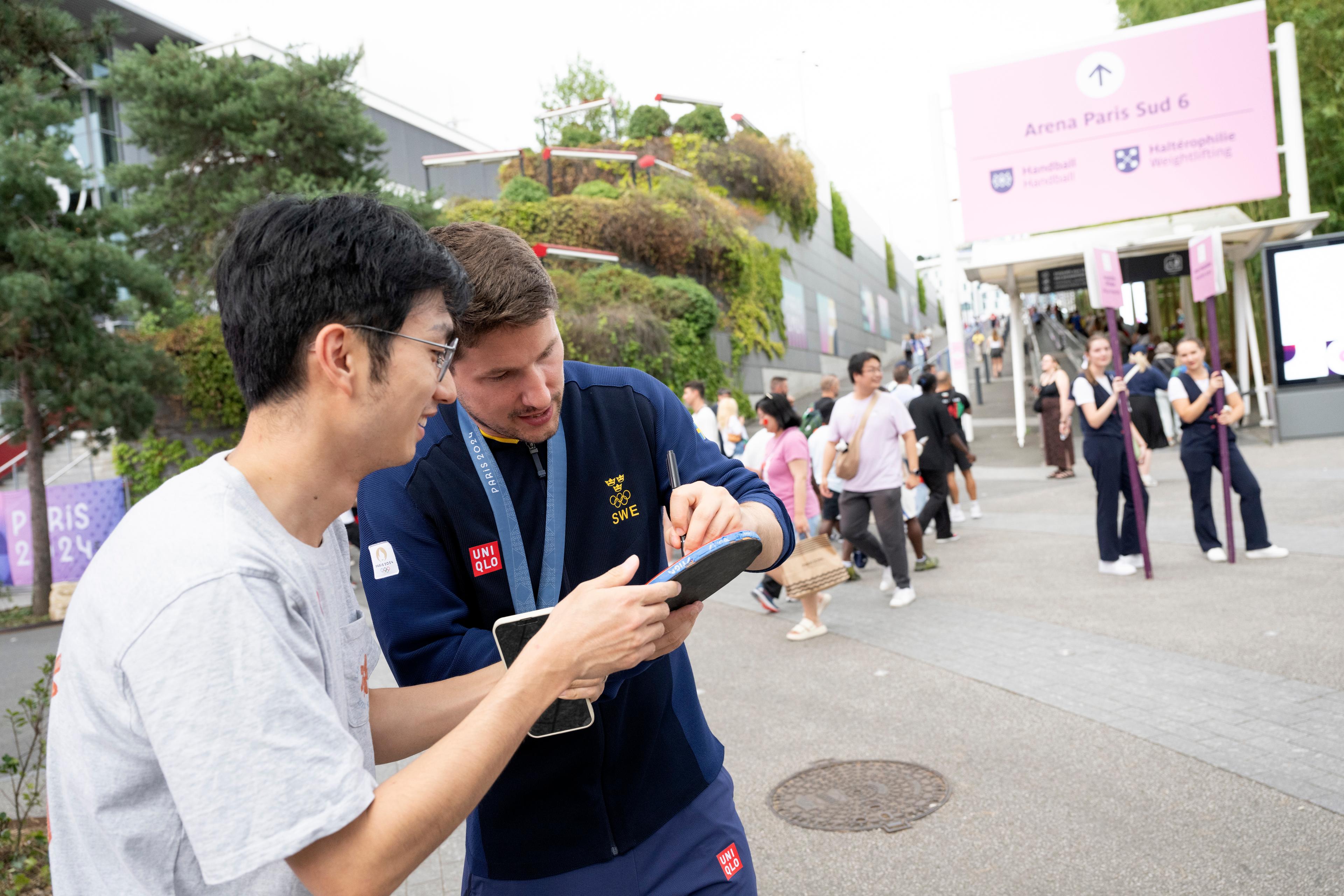 Kristian Karlsson skriver en autograf på ett bordtennisracket i Paris. Foto: Henrik Montgomery/TT