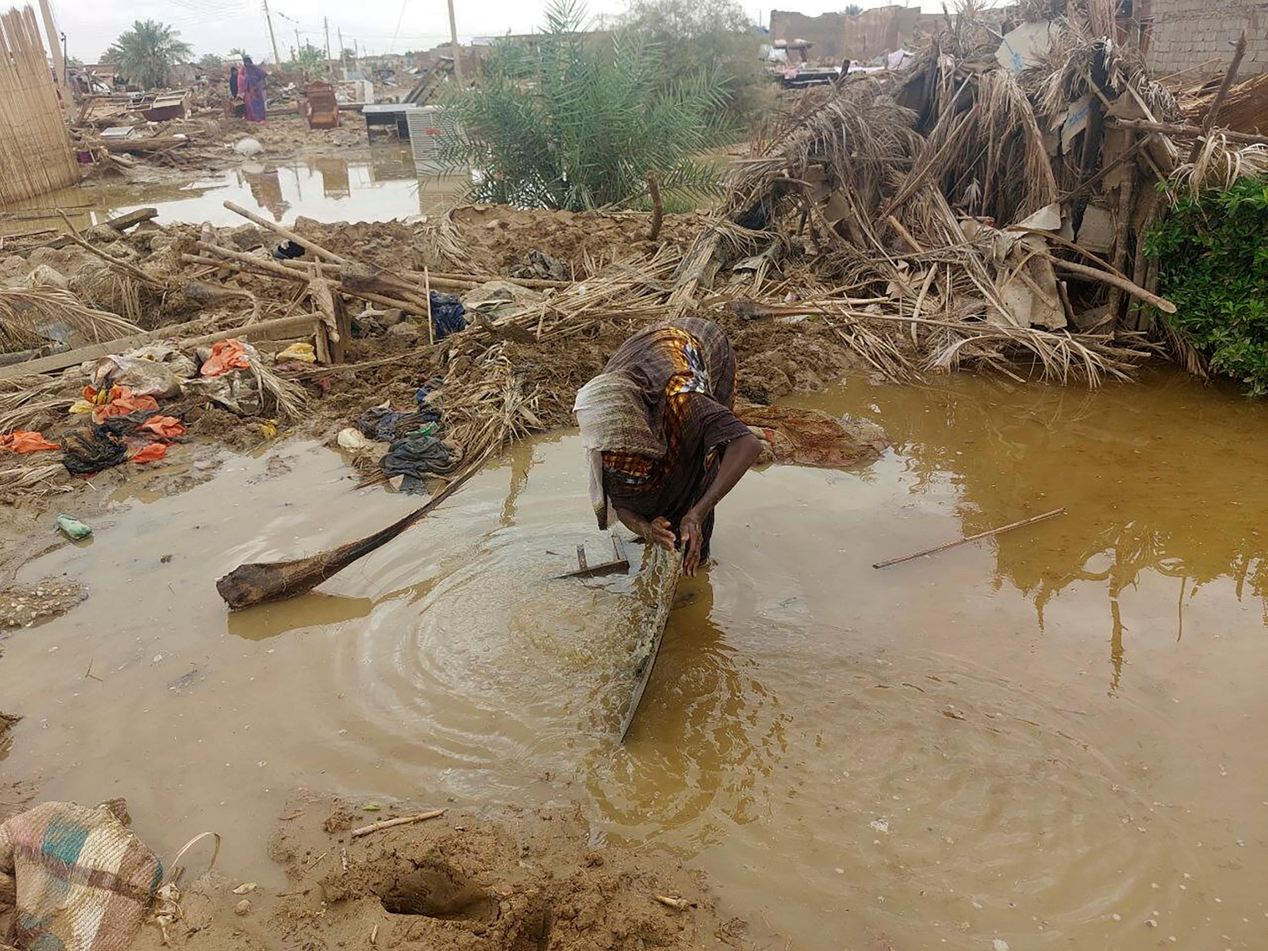 En kvinna i vadar i översvämningsvatten vid sitt hem i norra Sudan. Bilden togs förra veckan. Foto: Samira Hassan/AP/TT