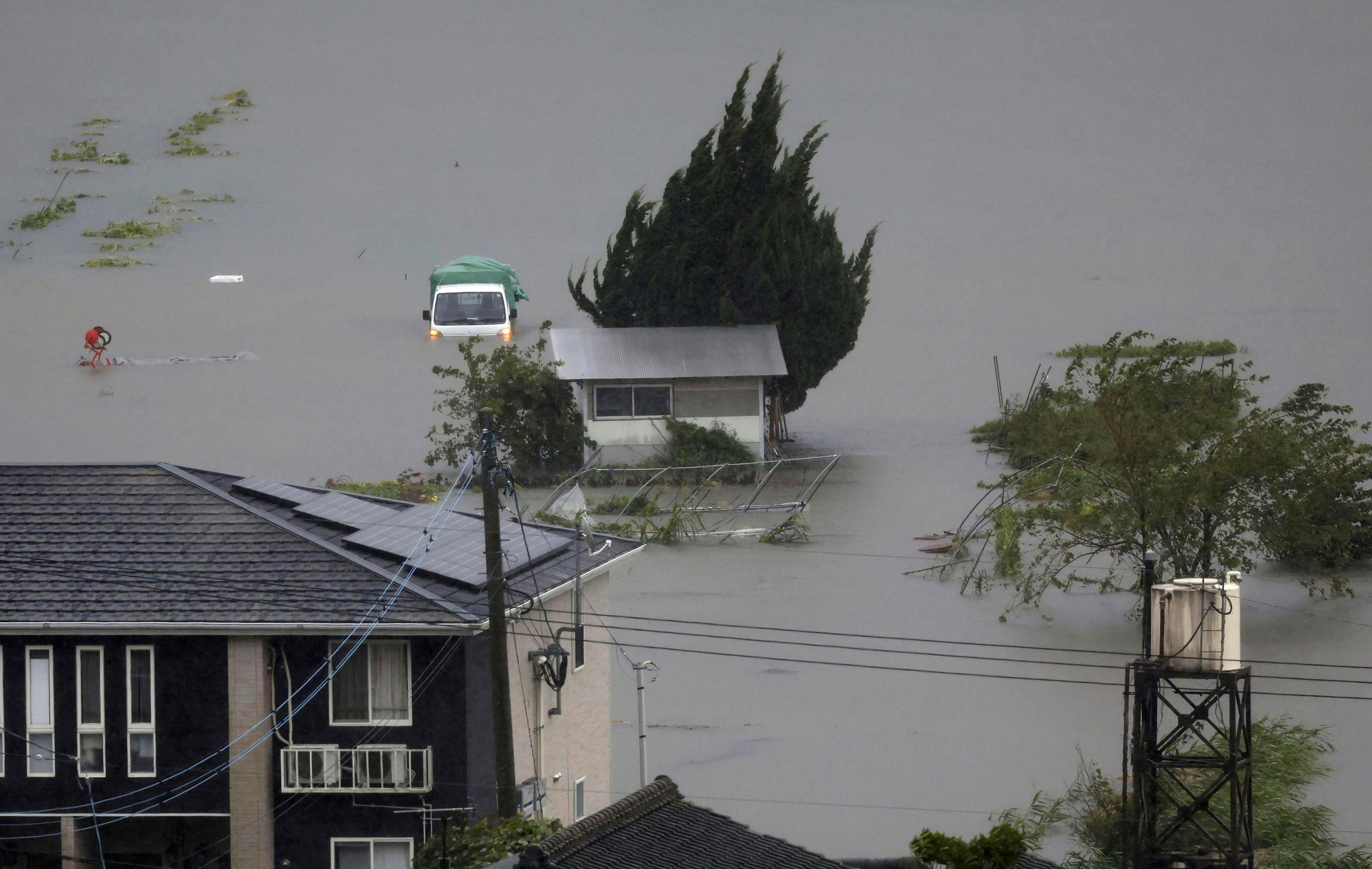 Översvämmade åkrar och vägar i prefekturen Oita i västra Japan på torsdagen. Foto: Kyodo News via AP/TT