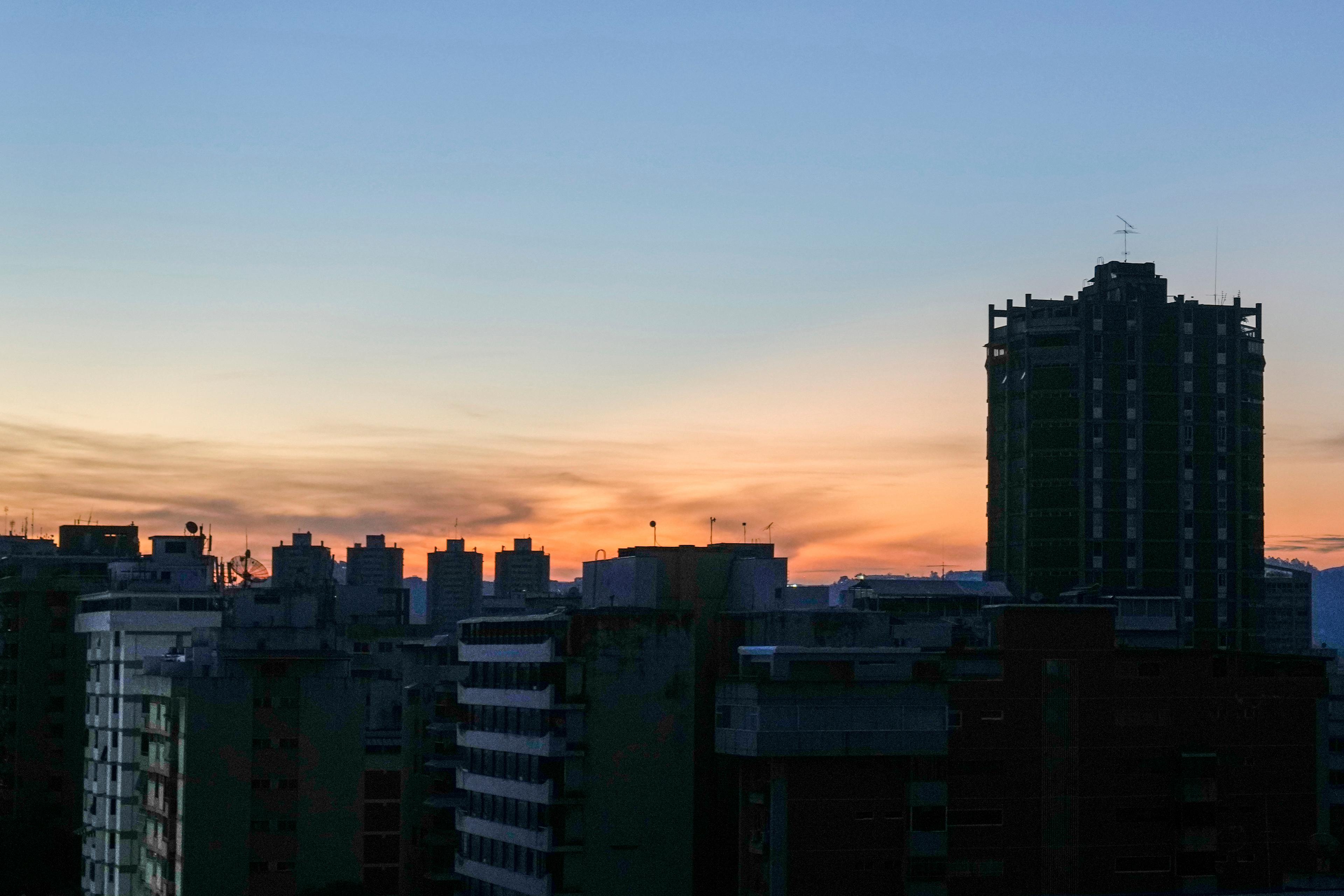 Mörklagda byggnader i Caracas på fredagsmorgonen. Foto: Ariana Cubillos/AP/TT