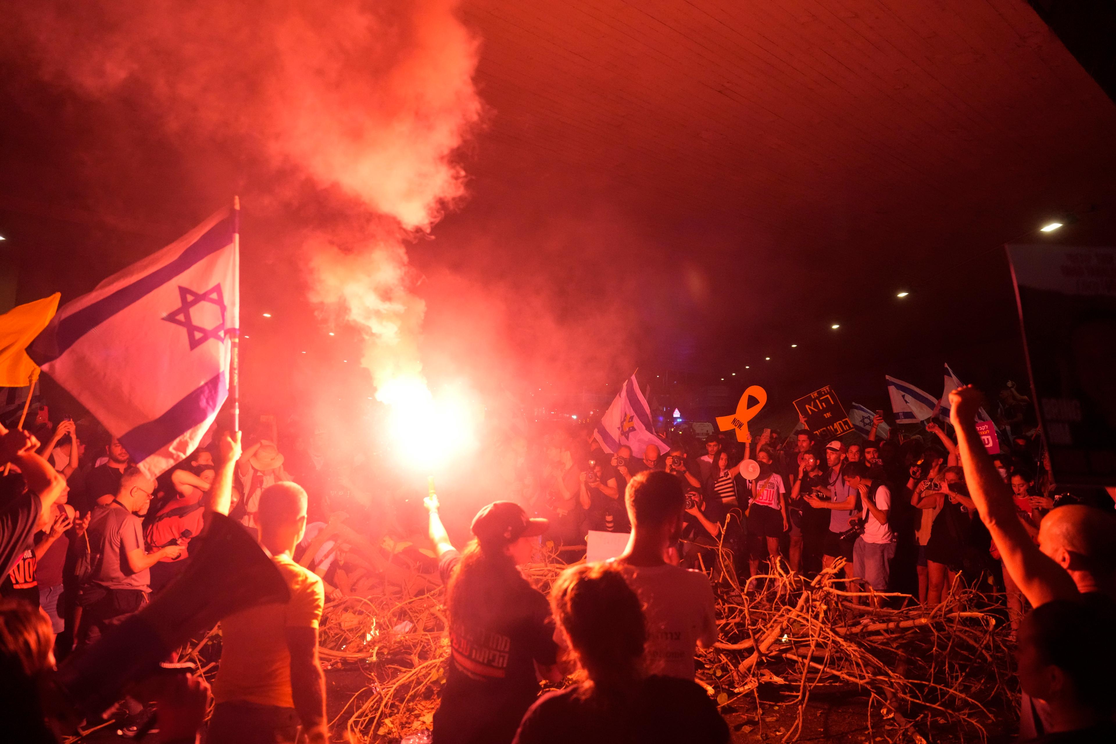 Demonstranter blockerar en väg i Tel Aviv på söndagskvällen. Foto: Ariel Schalit/AP/TT