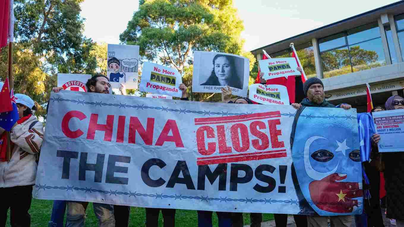 Demonstranter för uigurernas sak i Kina håller upp banderoller under Kinas premiärminister Li Qiangs besök i Adelaide, Australien, den 16 juni. Foto: Asanka Rarnayake/POOL/AFP via Getty Images