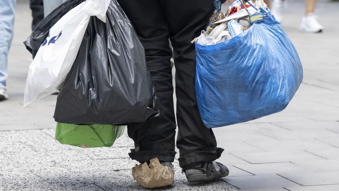 En gammal man bär sina ägodelar i påsar i vimlet i centrala Stockholm.   Foto: Fredrik Sandberg/TT