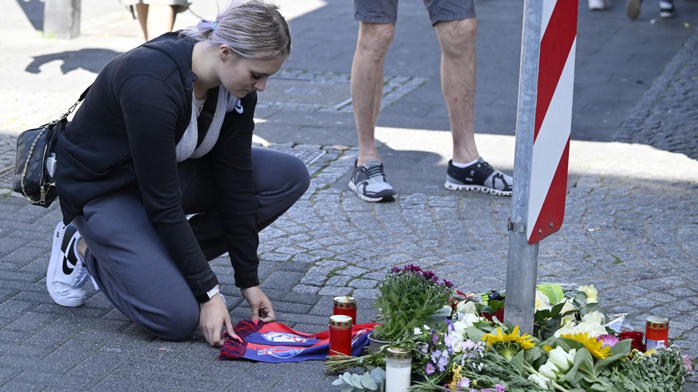 En kvinna knäböjer vid ett provisoriskt minnesmärke med blommor och ljus den 24 augusti för de personer som föll offer för ett knivdåd på en festival i Solingen i västra Tyskland dagen innan. Foto: Roberto Pfeil/AFP via Getty Images