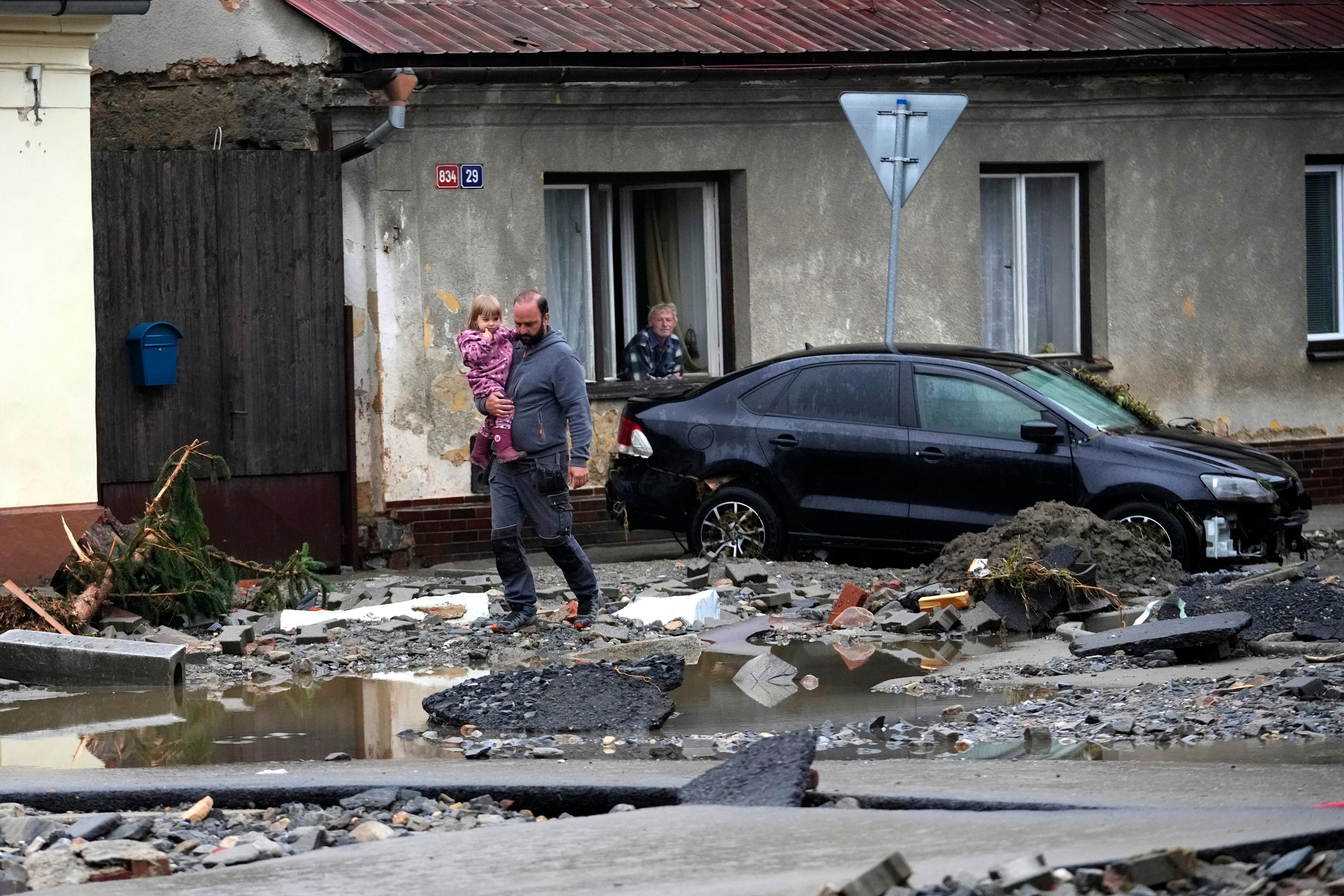 Invånare i hårt drabbade Jeseník går omkring bland bråte i översvämningarnas spår. Bilden togs i måndags. Foto: Petr David Josek/AP/TT