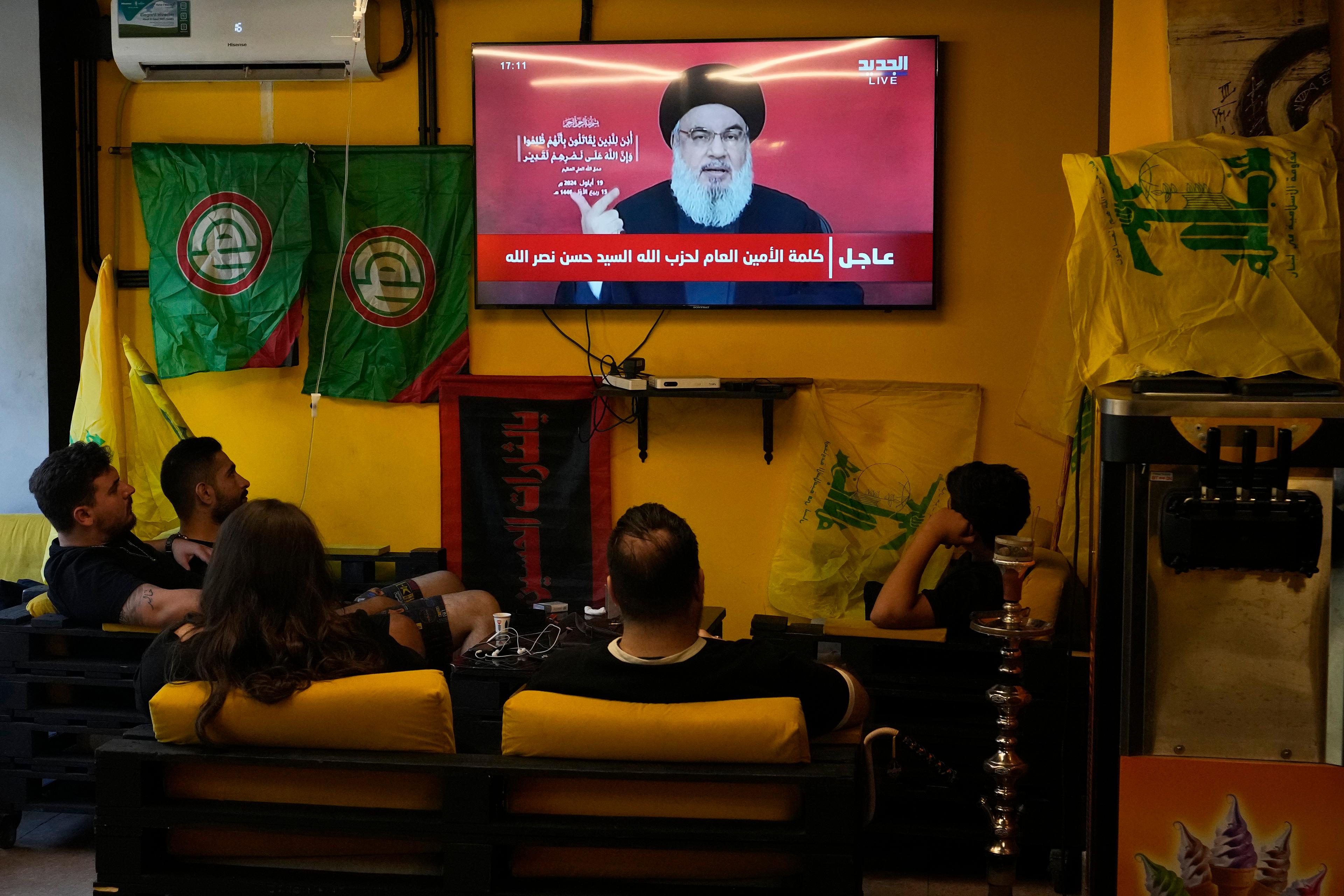 Hizbollah-ledaren Hassan Nasrallahs tal på torsdagen visas på ett café i Beiruts södra förorter, där stödet till shiamilisen är stort. Foto: Hassan Ammar/AP/TT