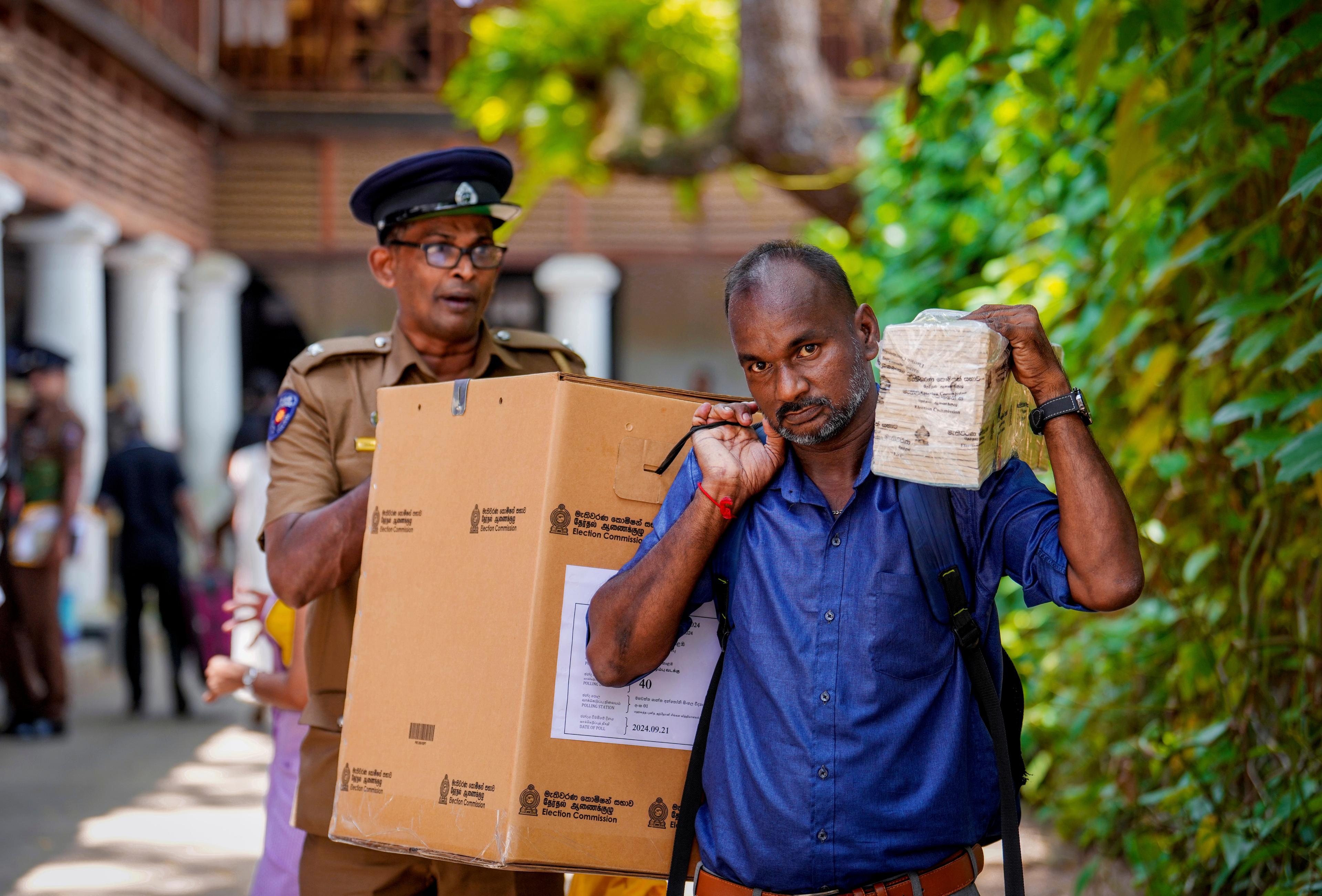 En valförrättare i Sri Lanka på väg till vallokalen med valurnan, inför landets presidentval. Foto: Rajesh Kumar Singh/AP/TT