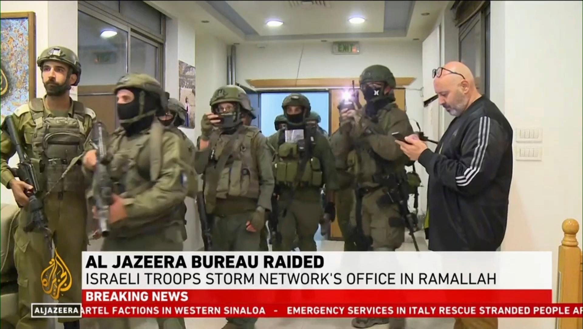 Bild ur Al Jazeeras direktsändning som visar israeliska soldater i tv-bolagets lokaler. Foto: Al Jazeera via AP/TT