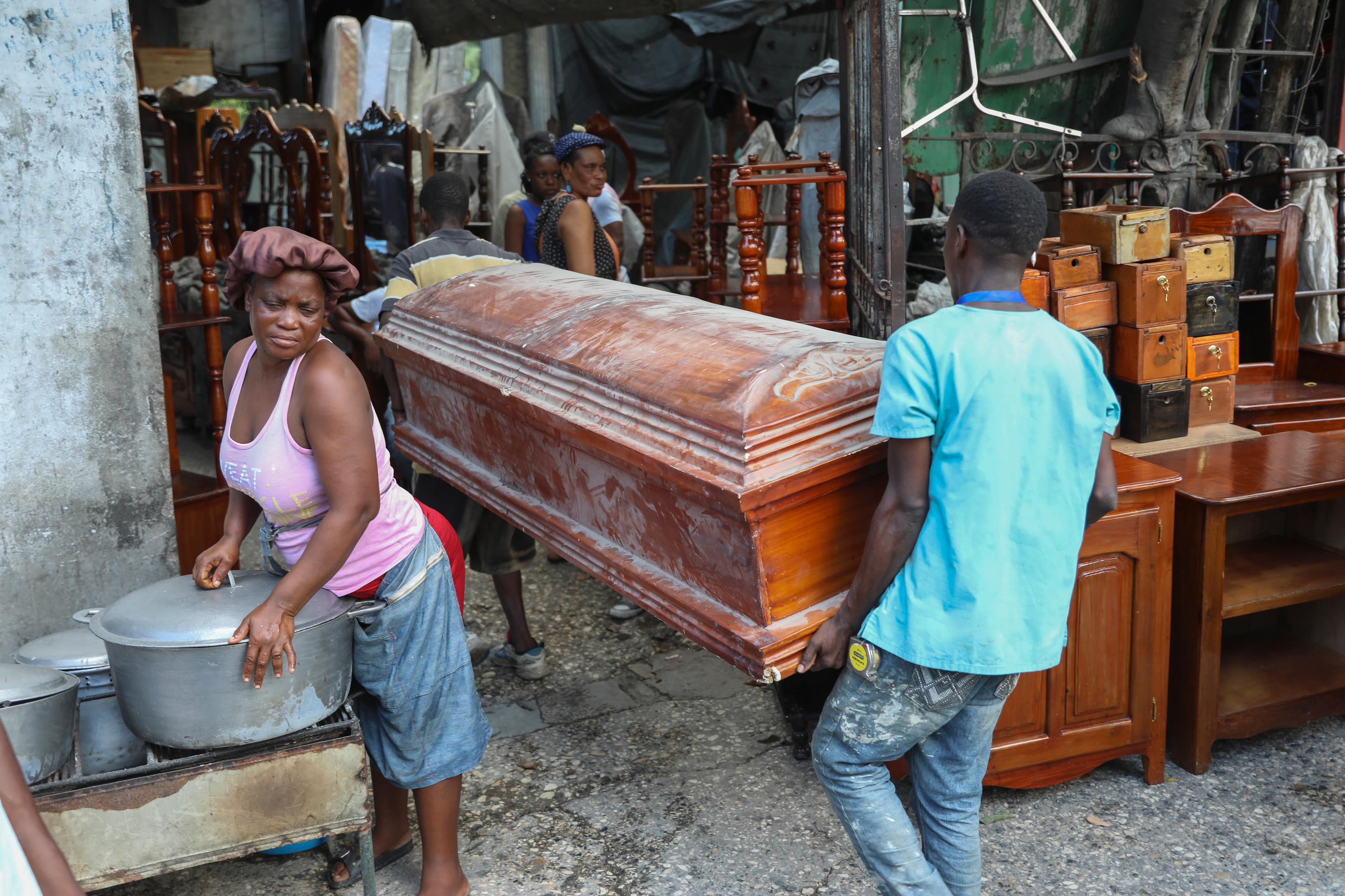 En tom kista bärs förbi en gatuförsäljare i Haitis huvudstad Port-au-Prince tidigare i september. Foto: Odelyn Joseph/AP/TT