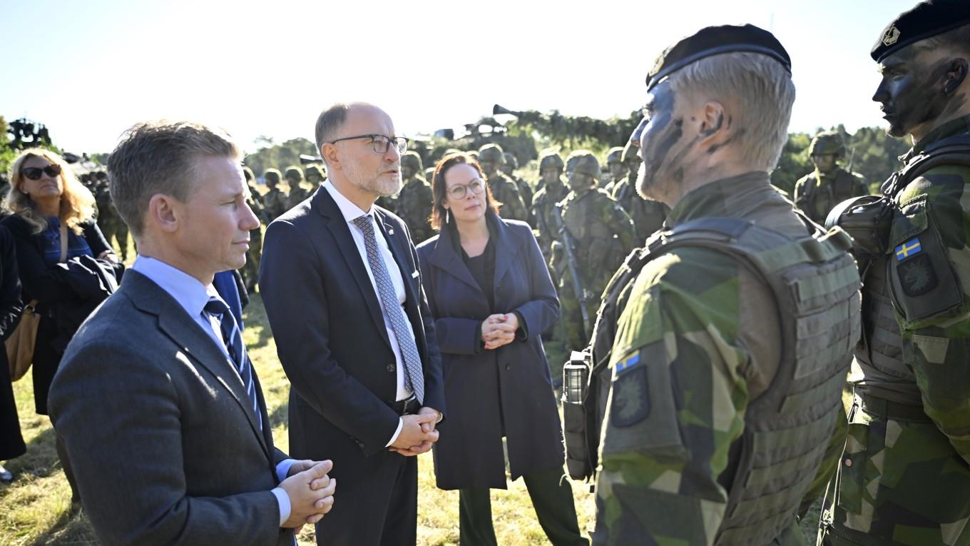 Lettlands försvarsminister Andris Spruds, med Sveriges försvarsminister Pål Jonsson (M) och utrikesminister Maria Malmer Stenergard (M) vid sin sida, talar till de soldater som efter årsskiftet åker till Lettland för att ingå i den multinationella Natostyrkan. Foto: Johan Nilsson/TT