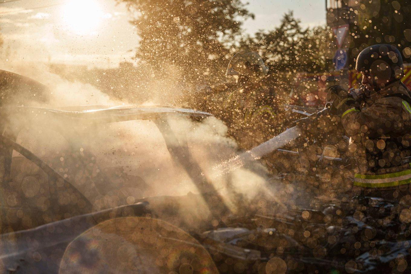 Brandmän i Sumy i norra Ukraina arbetar med att släcka en bildbrand efter ett ryskt flyganfall mot ett bostadsområde på lördagen. Foto: Evgeniy Maloletka/AP/TT