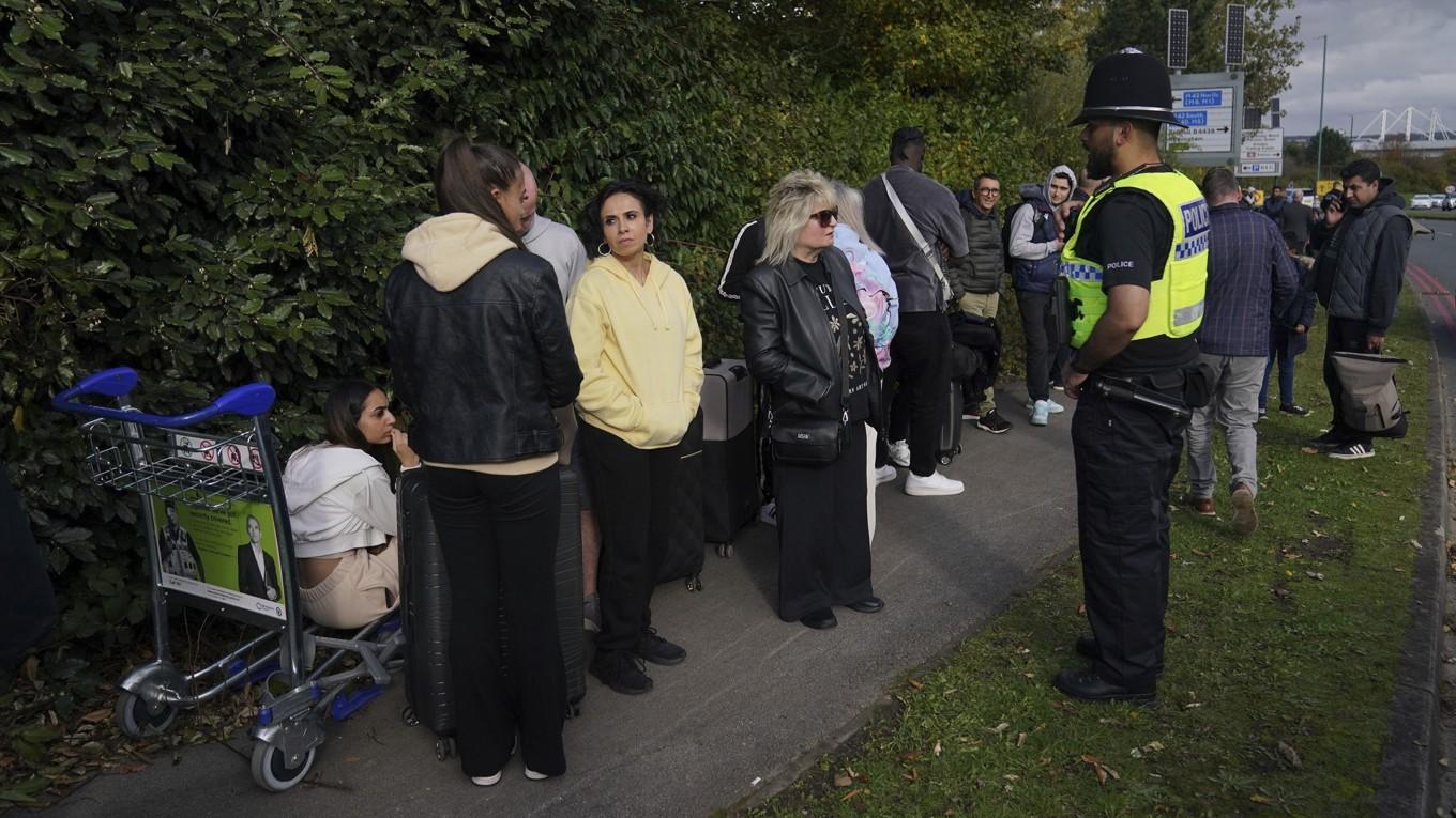 Köande väntar utanför Birminghams flygplats efter evakuering på grund av hot. Foto: Jacob King/PA/AP/TT