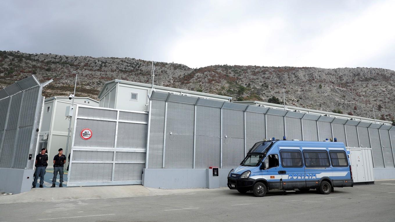 Italienska poliser vid ingången till ett nybyggt asylcenter i Shengjin i Albanien den 11 oktober. Foto: Adnan Beci/AFP via Getty Images