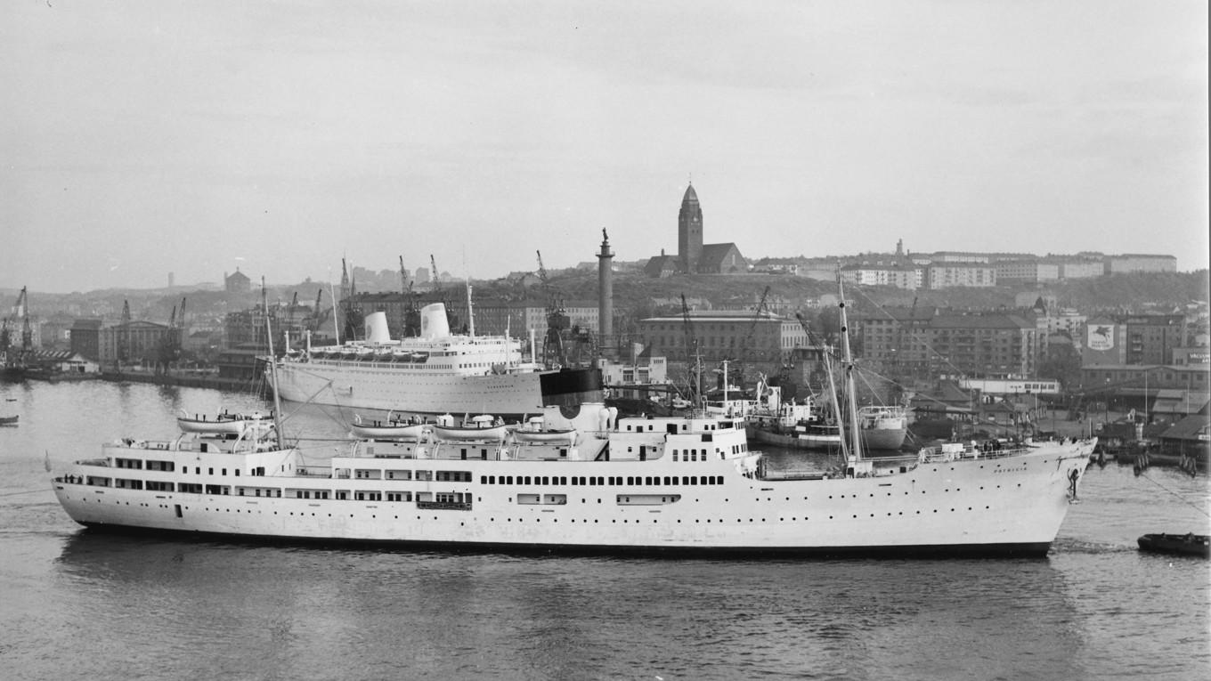 Amerikabåtarna på bilden, M/S Patricia och M/S Stockholm, utgick precis som sina systerfartyg från Stigbergskajen vid emigrationskontoret – ”Amerika-” eller ”Betongskjulet” – i Göteborg med slutdestination Pir 97 vid West 57th Street i New York. Mellan dessa ändhållplatser kunde även stopp i Köpenhamn, Oslo och Halifax i Kanada ingå i rutterna. Vid New Yorks inlopp tronade den imposanta Frihetsgudinnan. Naturligtvis ville inte den framåtskridande Svenska Amerika Linien vara sämre – passagerarna som anlöpte Göteborgs hamn skulle även de välkomnas av en vacker dam. 1934 lät man resa Ivar Johnssons sjöfartsmonument ”Kvinna vid havet”, ”Sjömanshustrun”, som hon kallas i folkmun. Än i dag blickar statyn ut över Göteborgs hamn från sin kolonn vid Sjöfartsmuseet på Stigberget. Foto: Public Domain