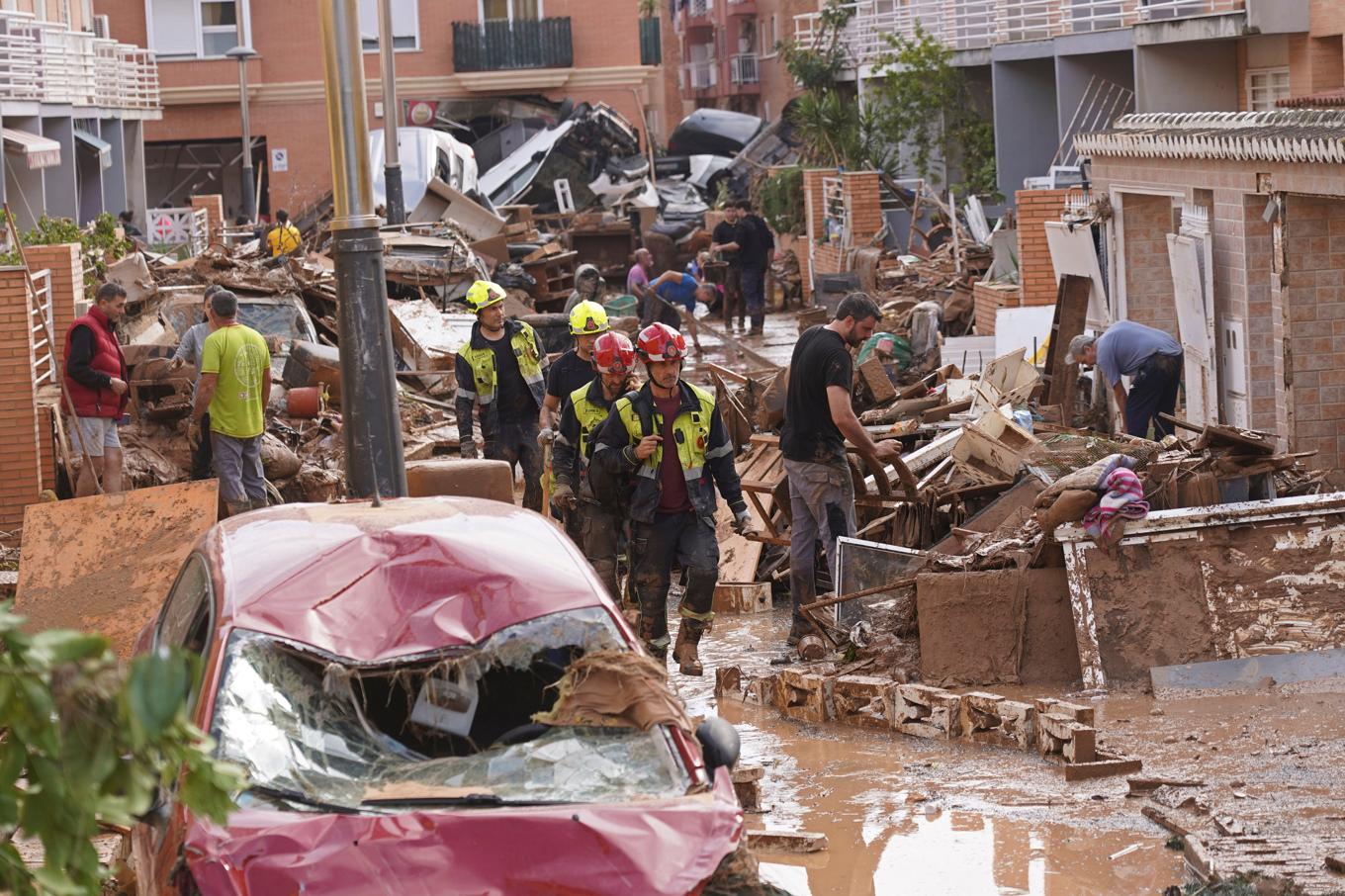 Brandmän och boende i området Massanassa utanför Valencia försöker städa upp efter den katastrofala översvämningen. Bild från fredagen. Foto: Alberto Saiz/AP/TT