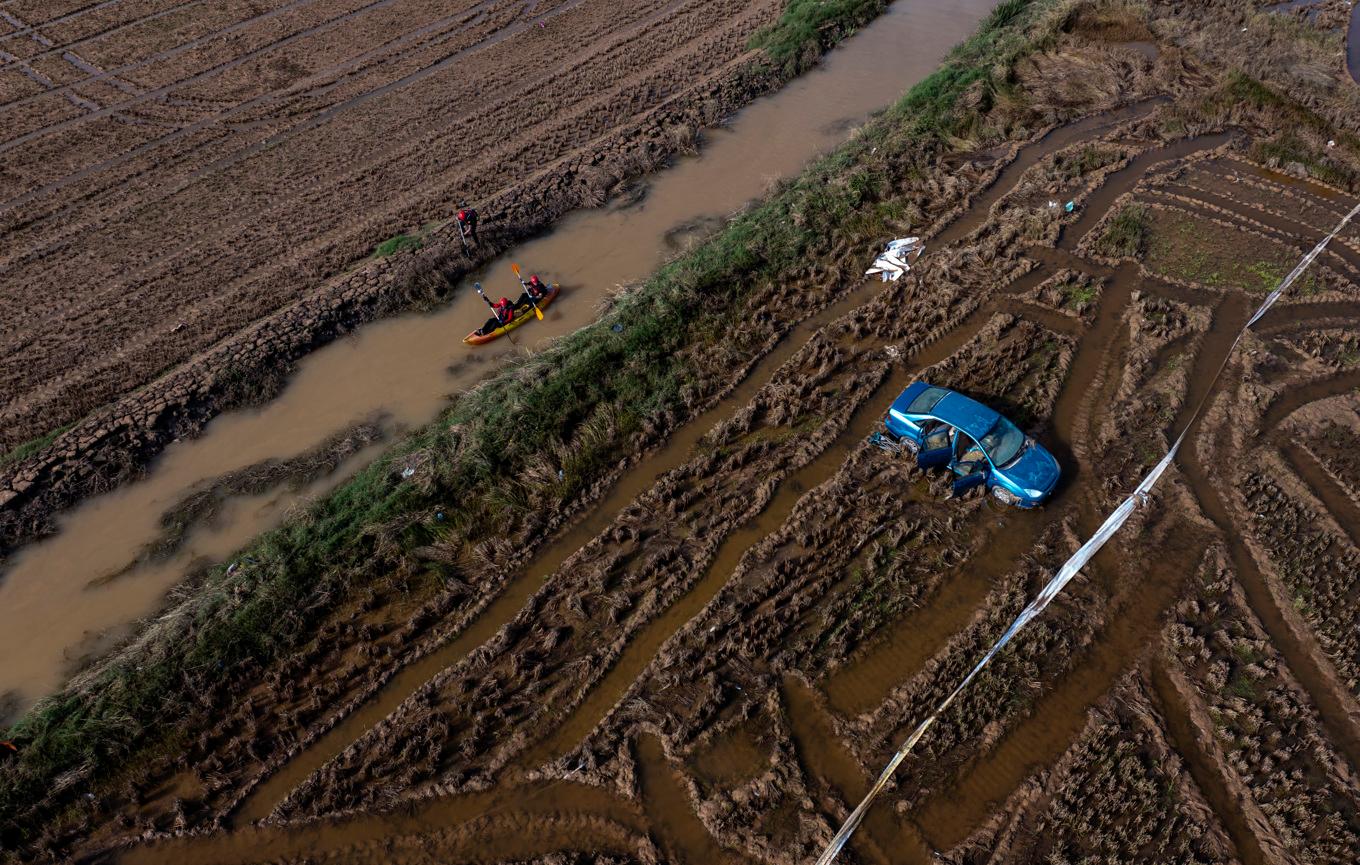 Räddningsarbetare i kanot söker efter döda i ett område i Valencias utkant. Bilden togs i fredags. Foto: Emilio Morenatti/AP/TT