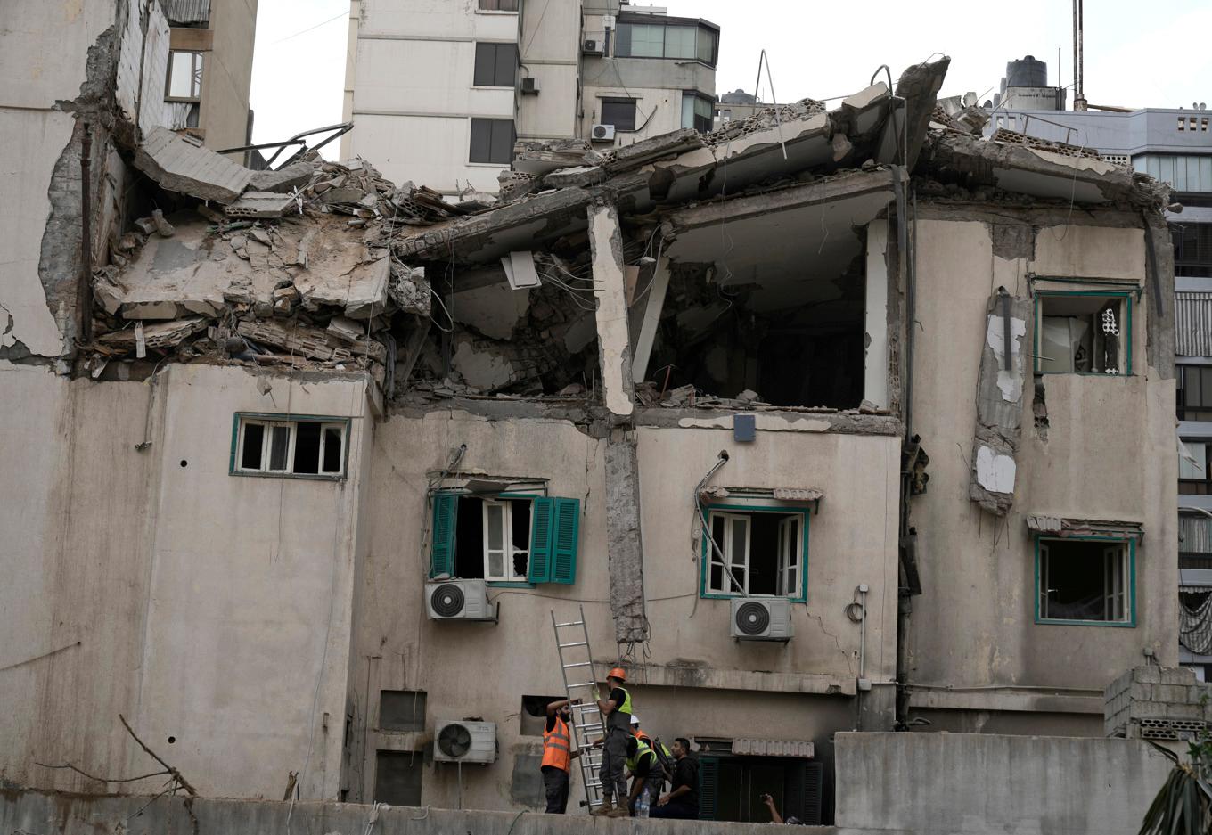 Räddningspersonal arbetar vid den träffade byggnaden i centrala Beirut. Foto: Bilal Hussein/AP/TT