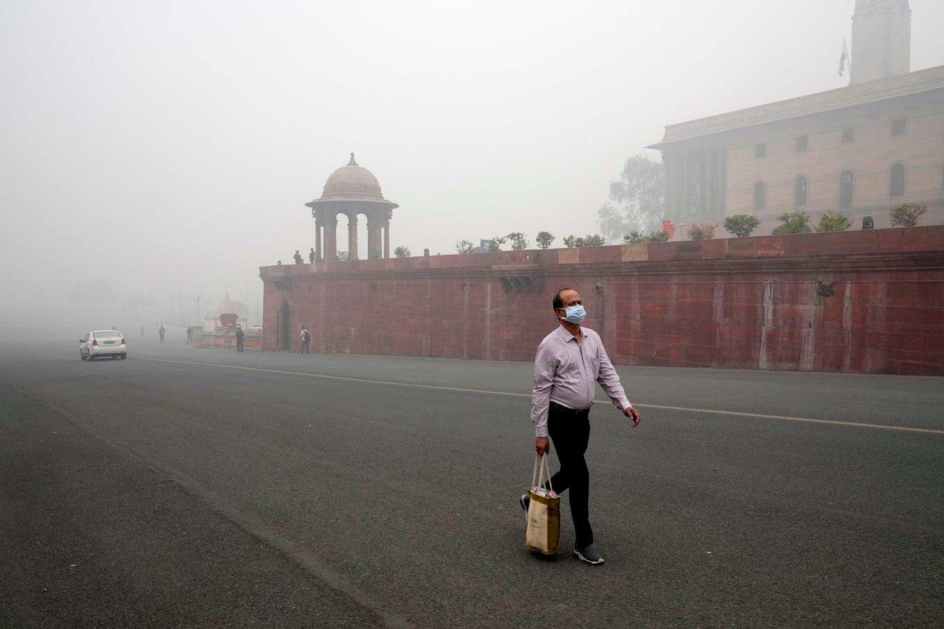 En kontorsarbetare på väg till jobbet i det smogtäckta Delhi. Foto: Manish Swarup/AP/TT