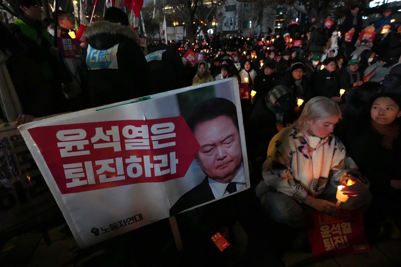 Demonstranter på Seouls gator kräver att president Yoon Suk-Yeol avgår efter beslutet i tisdags då han utlyste undantagstillstånd men tvingades dra tillbaka det bara sex timmar senare sedan parlamentet gått emot honom. Foto: Lee Jin-man/AP/TT