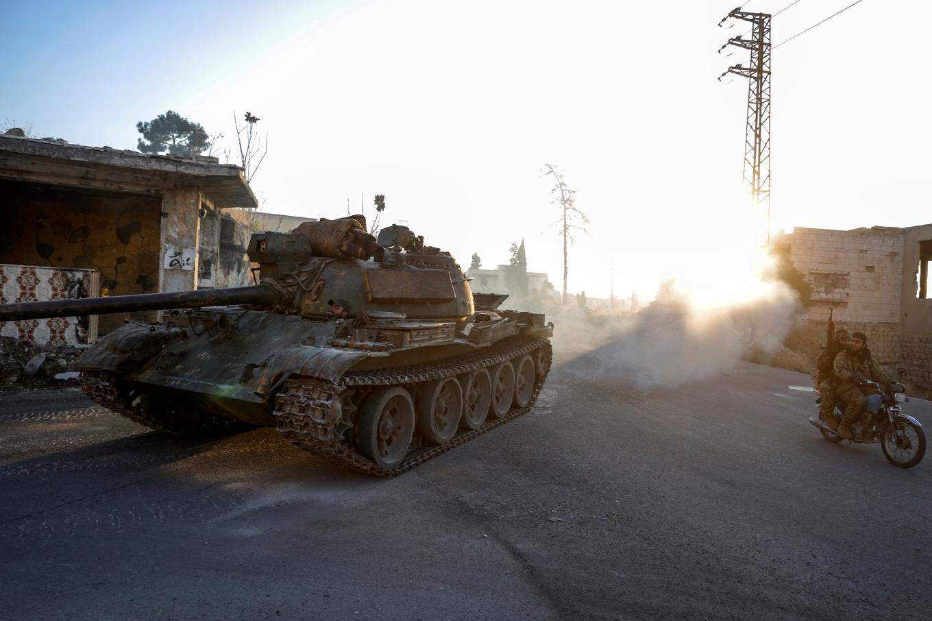 Milisstyrkor kör en stridsvagn som beslagtagits från den syriska armén i staden Maarat al-Numan söder om Idlib. Bilden togs tidigare i veckan. Foto: Omar Albam/AP/TT