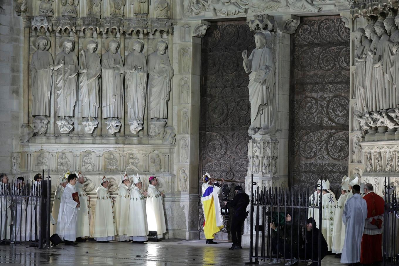 Paris ärkebiskop Laurent Ulrich knackade symboliskt tre gånger på Notre Dames dörrar. Foto: Teresa Suarez/AP/TT