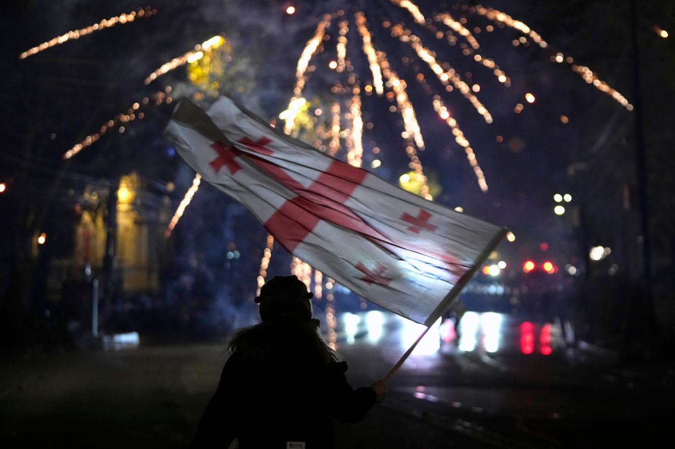 En demonstrant med Georgiens flagga i Tblisi natten mot lördagen. Foto: Pavel Bednyakov