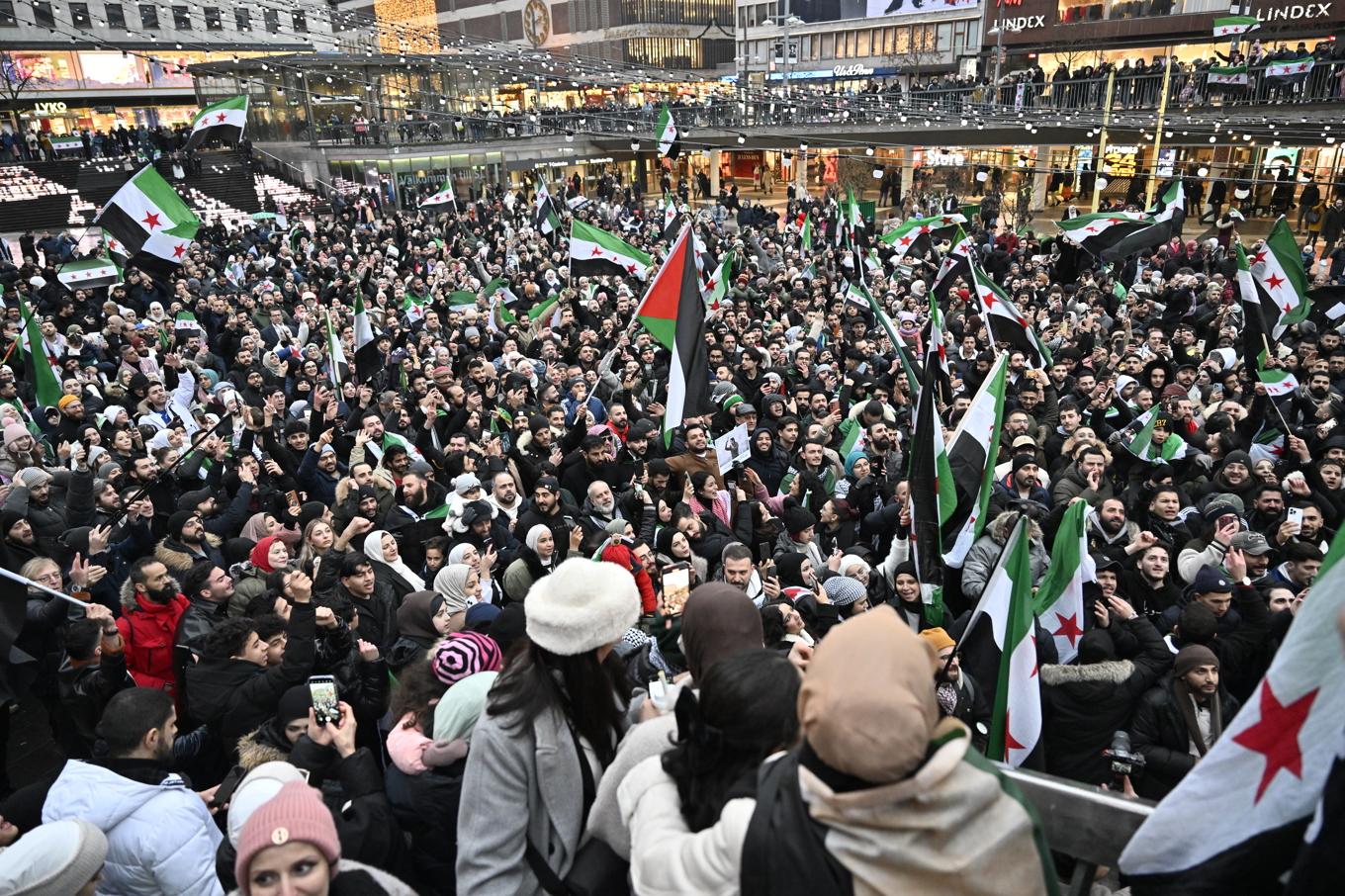 Syrier firar Assadregimens fall på Sergels torg i Stockholm på söndagen. Foto: Jonas Ekströmer/TT