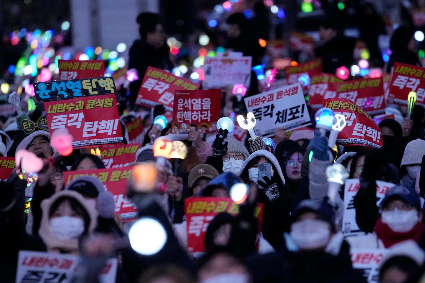 Människor demonstrerar på söndagen utanför parlamentet i Seoul för att få presidenten Yoon Suk-Yeol ställd inför riksrätt. Foto: Ahn Young-Joon/AP/TT