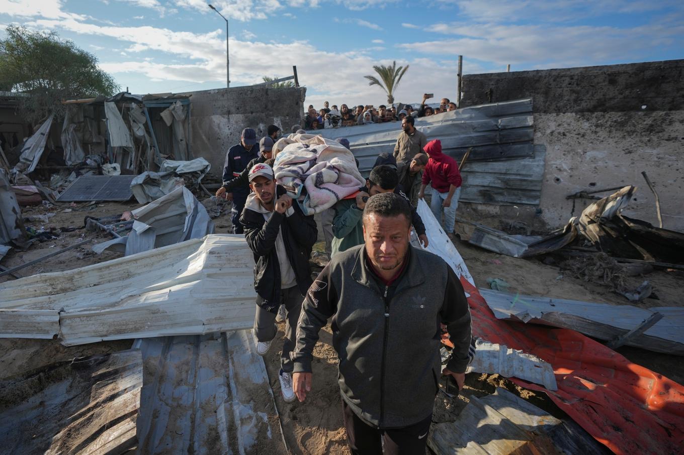 En kropp bärs bort efter en israelisk attack mot al-Mawasi nära Khan Yunis i södra Gazaremsan tidigare i december. Foto: Abdel Kareem Hana/AP/TT