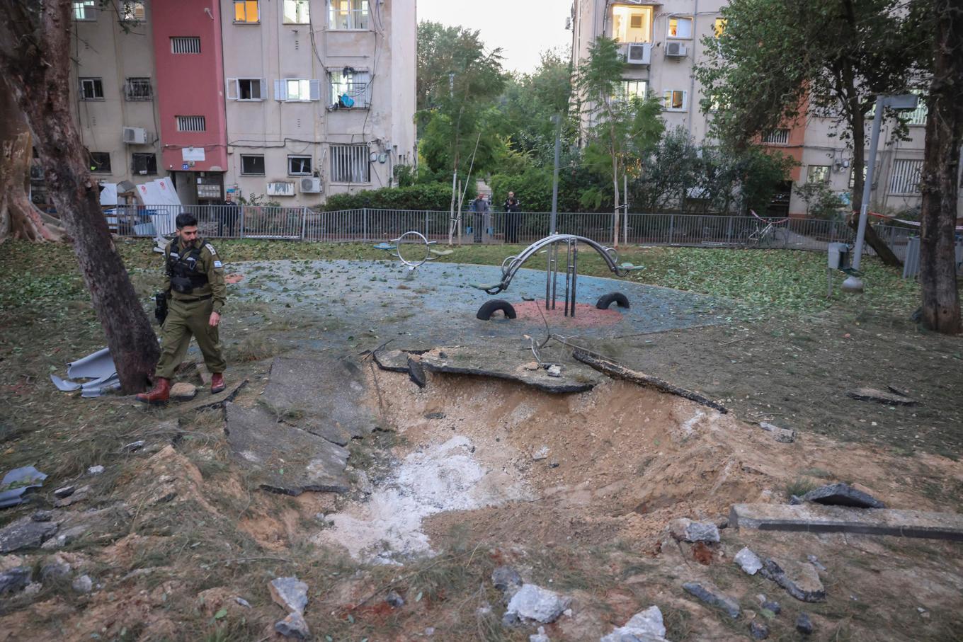 En israelisk soldat betraktar platsen där projektilen slog ned i Tel Aviv-området på lördagen. Foto: Tomer Appelbaum/AP/TT