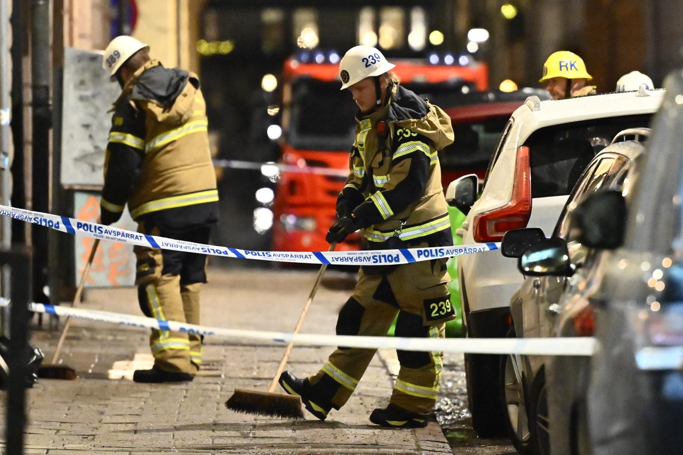 Personal från räddningstjänst sopade bort glas från trottoaren efter explosionen på Östermalm i Stockholm på lördagskvällen. Foto: Anders Wiklund/TT