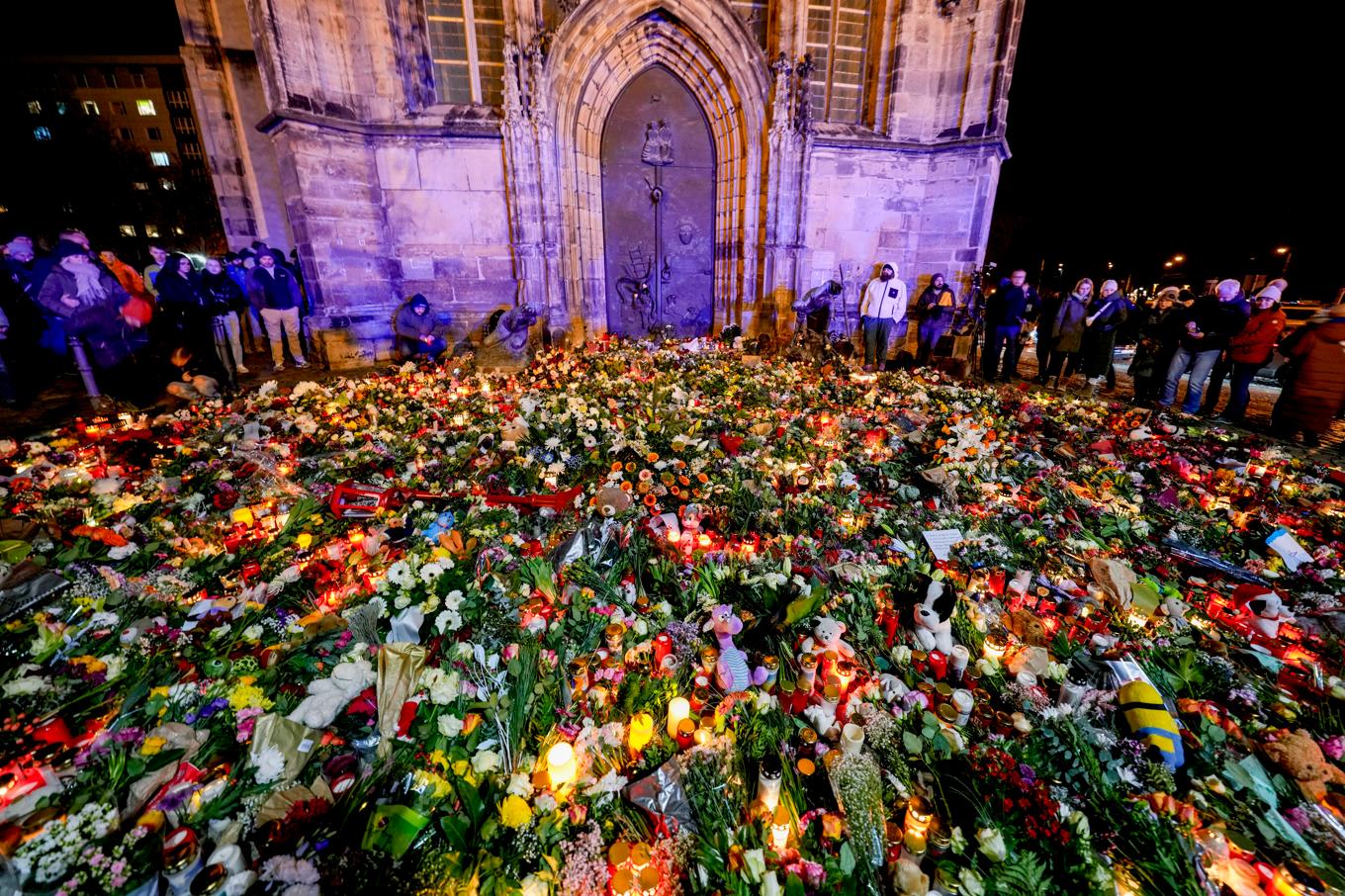 Människor har lämnat blommor och ljus framför Johannis-katedralen nära julmarknaden i Magdeburg, Tyskland. Bild tagen under lördagen. Foto: Michael Probst/AP/TT