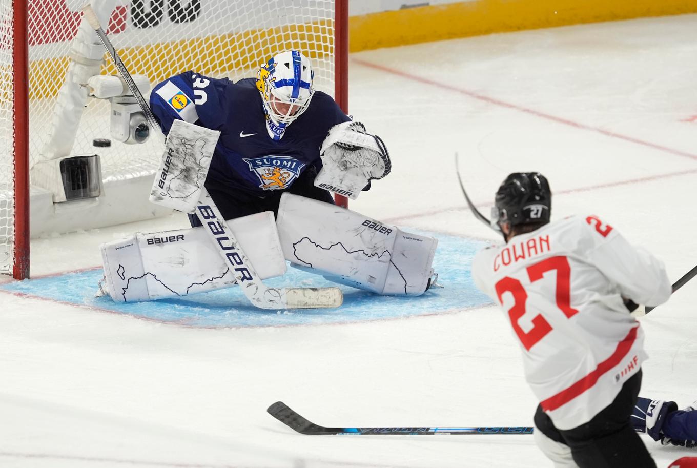 Kanadas forward Easton Cowan sätter pucken bakom finske Petteri Rimpinen i nattens möte. Foto: Adrian Wyld/AP/TT