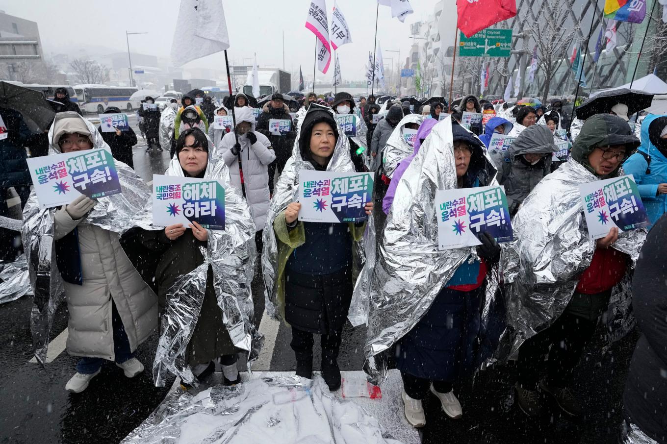 Demonstranter vill att president Yoon Suk-Yeol ska gripas. På skyltarna står det ”Upplös det styrande Folkets maktparti” och ”Grip Yoon Suk-Yeol”. Foto: Ahn Young-Joon/AP/TT