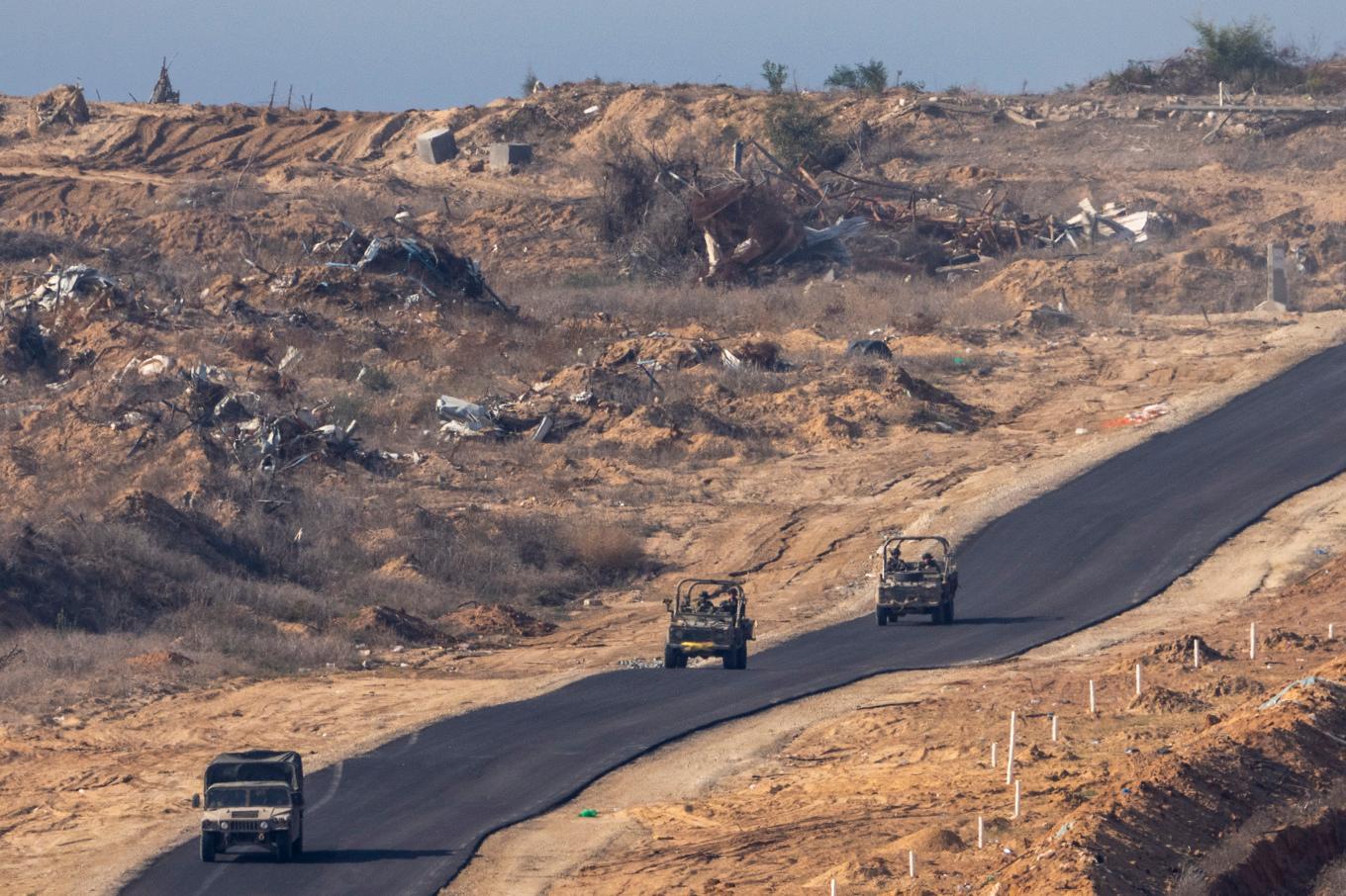 Israeliska militärfordon i Gaza, här sett från södra Israel. Foto: Ariel Schalit/AP/TT