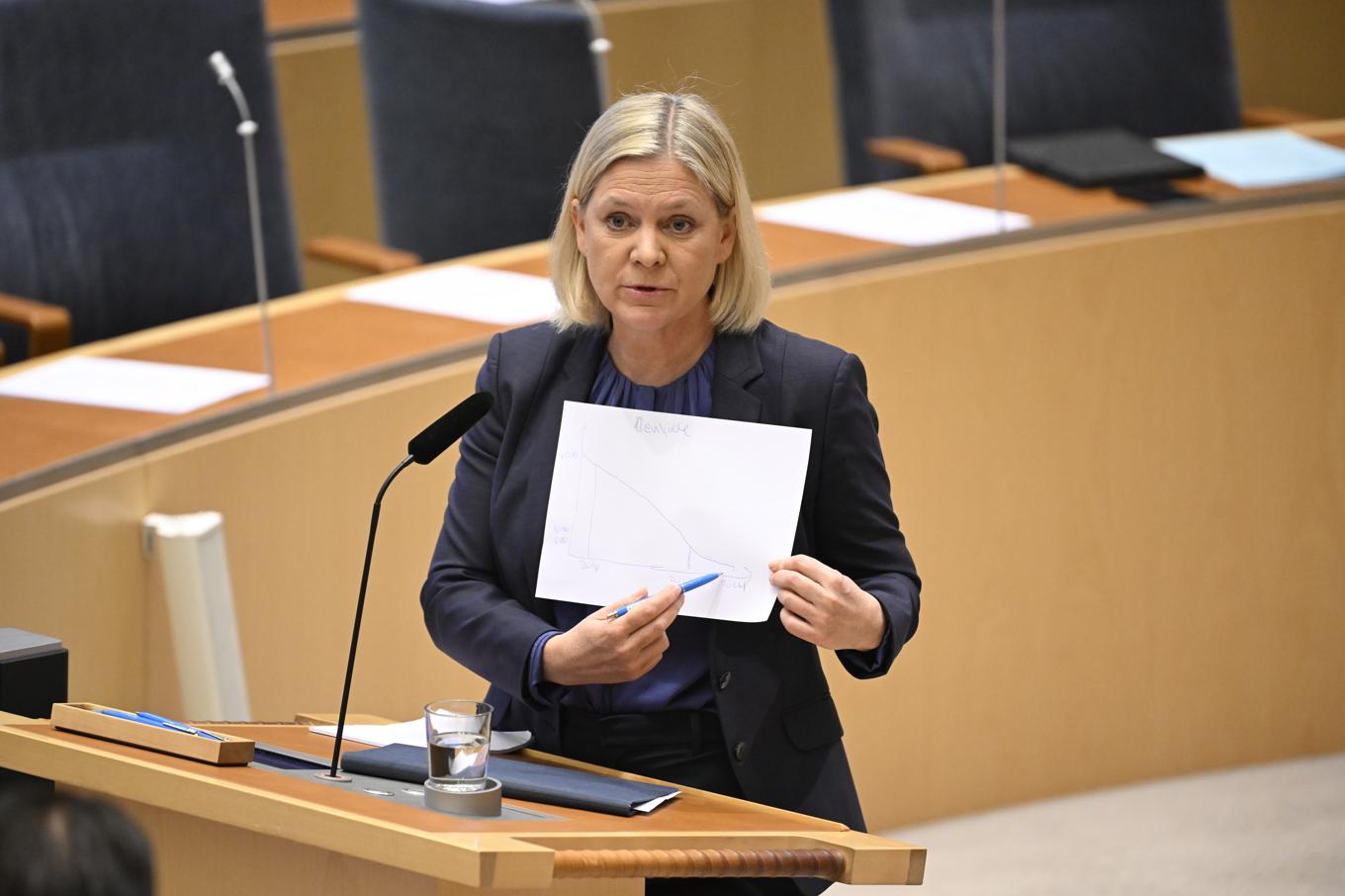 Magdalena Andersson (S) visar upp en lapp på Sveriges invandringskurva under onsdagens partiledardebatt i riksdagen. Foto: Jessica Gow/TT