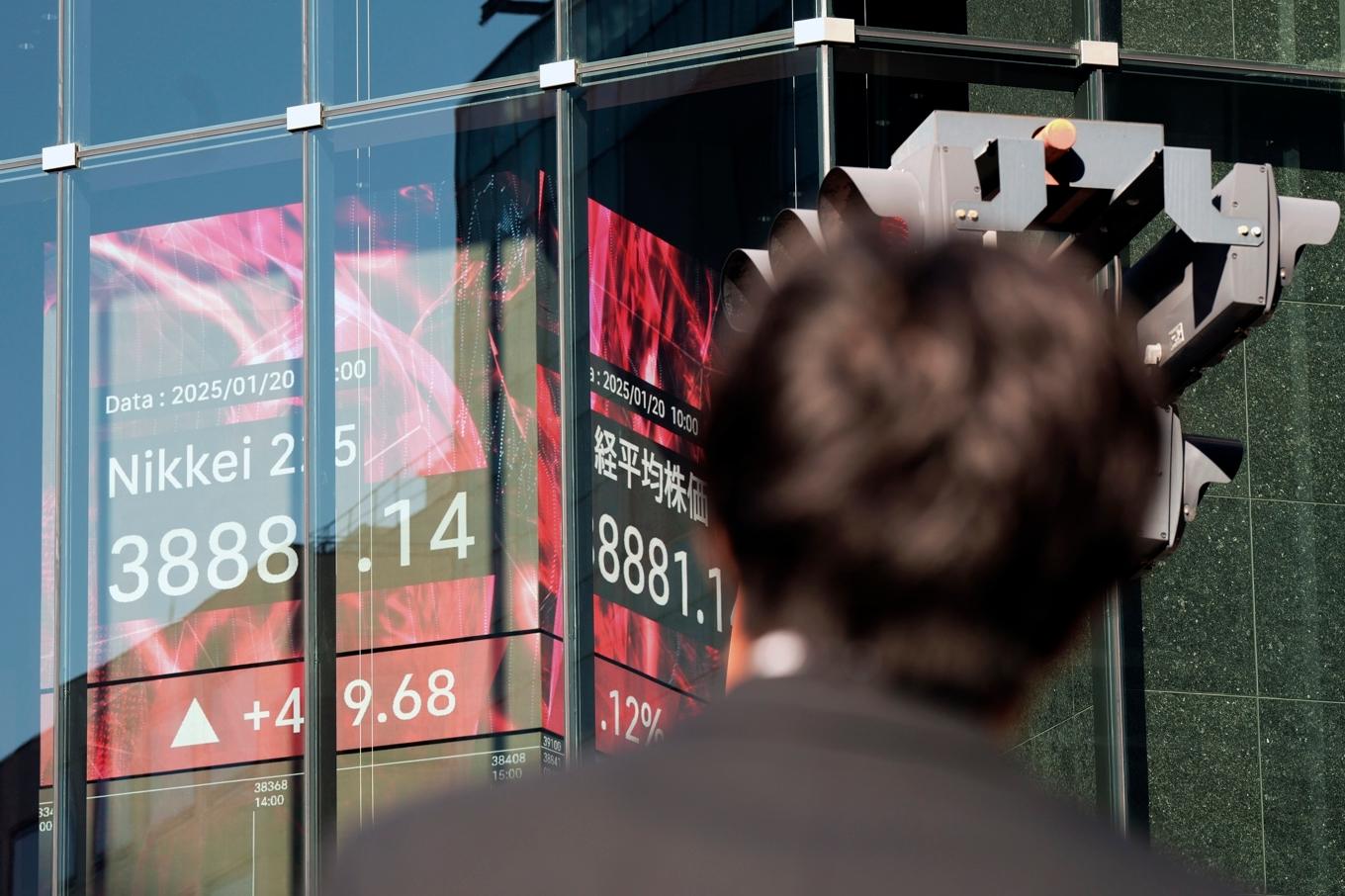 En person tittar på en elektronisk tavla som visar börskursen för Nikkei 225 på måndagen. Foto: Eugene Hoshiko/AP/TT