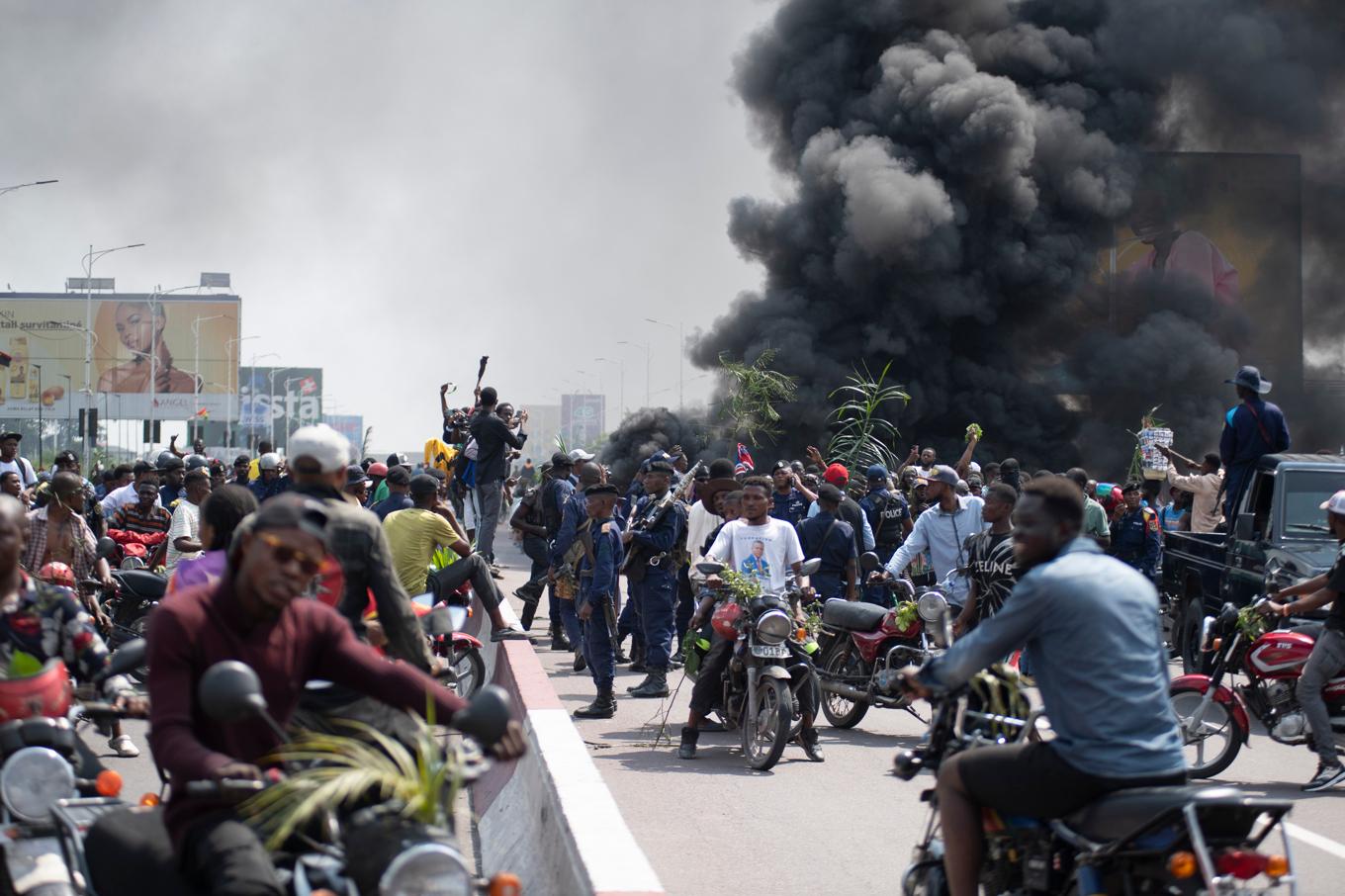 Demonstranter och nyfikna på gatorna i Kinshasa på tisdagen. Foto: Samy Ntumba Shambuyi/AP/TT