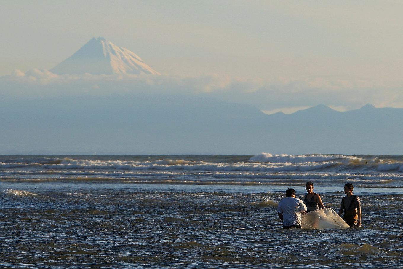 Fiskare i New Plymouth, Nya Zeeland, med berget Taranaki i bakgrunden. Vissa nyzeeländska stammar betraktar berget som sin förfader. Foto: Hagen Hopkins/Getty Images