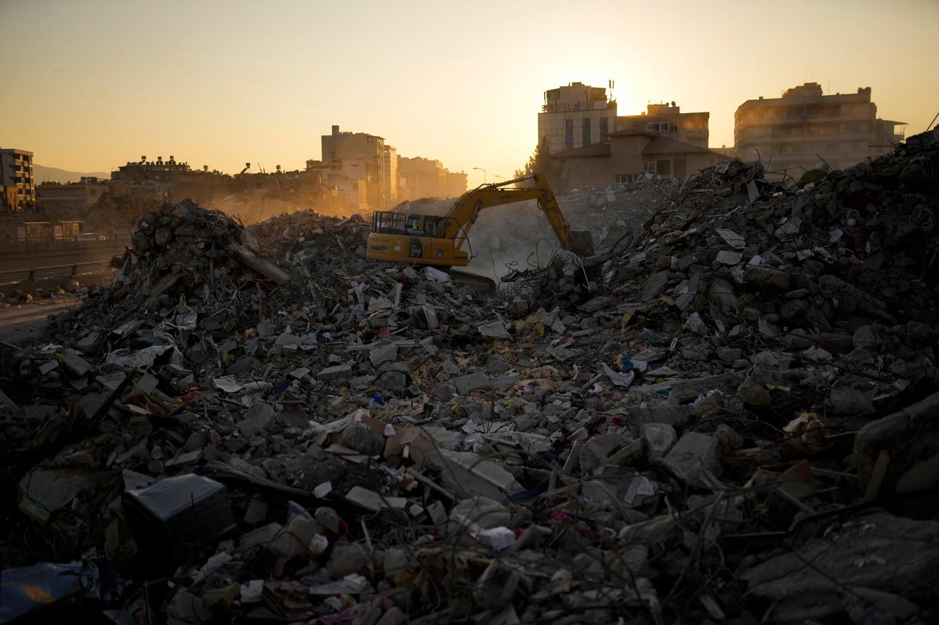 En grävskopa röjer bland bråte i Iskenderun i södra Turkiet efter den stora jordbävningen. Bild från februari 2023. Foto: Francisco Seco/AP/TT