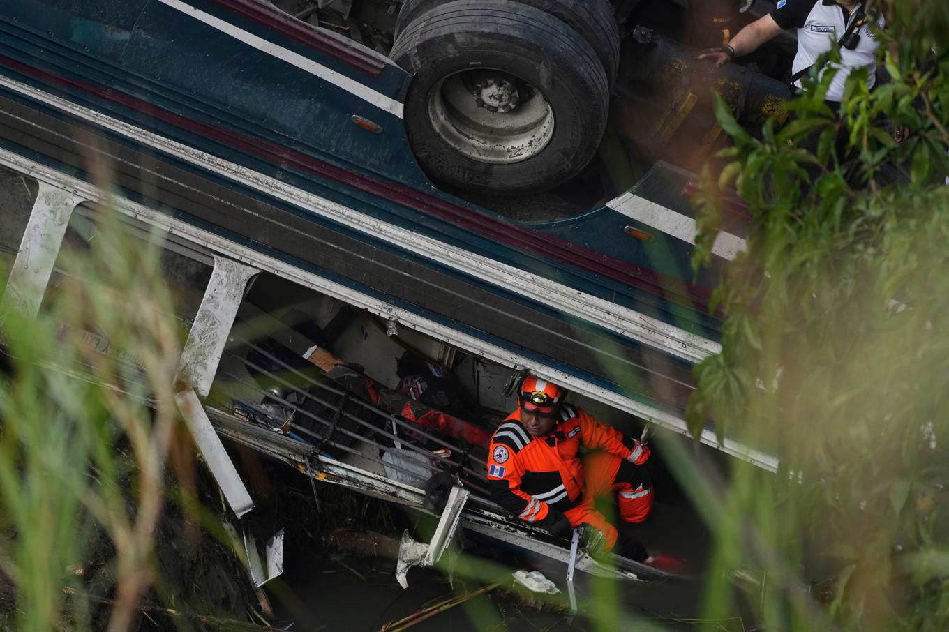 Räddningstjänsten arbetar vid bussen som störtat ned i ravin i Guatemala City. Foto: Moises Castillo/AP/TT