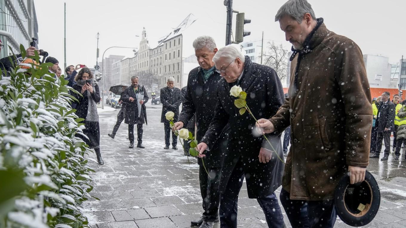 Bayerns ledare Markus Söder, Tysklands president Frank-Walter Steinmeier och Münchens borgmästare Dieter Reiter lämnar blommor vid platsen där över 30 personer skadades i ett dåd på torsdagen. Foto: Ebrahim Noroozi/AP/TT