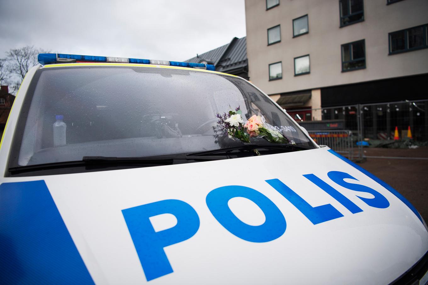 En polisbil med blommor fastsatta på vindrutan morgonen efter skolskjutningen på Risbergska skolan i Örebro. Arkivbild. Foto: Viktoria Bank / TT