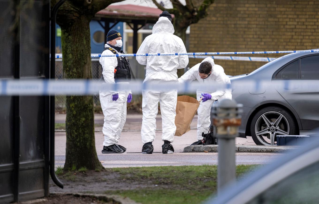 Kriminaltekniker och polis arbetar innanför avspärrningarna på en parkering vid Adolfsbergs centrum i Helsingborg efter en dödsskjutning den 5 april förra året. Foto: Johan Nilsson/TT