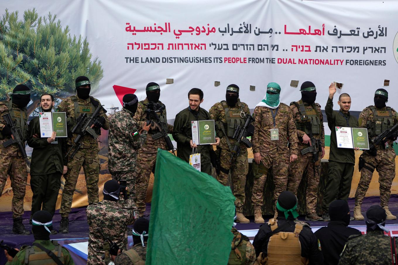 Tre av Hamas israeliska gisslan paraderas på en scen av terrorrörelsen före överlämnandet till Röda Korset och Israel. Foto: Abdel Kareem Hana/AP/TT